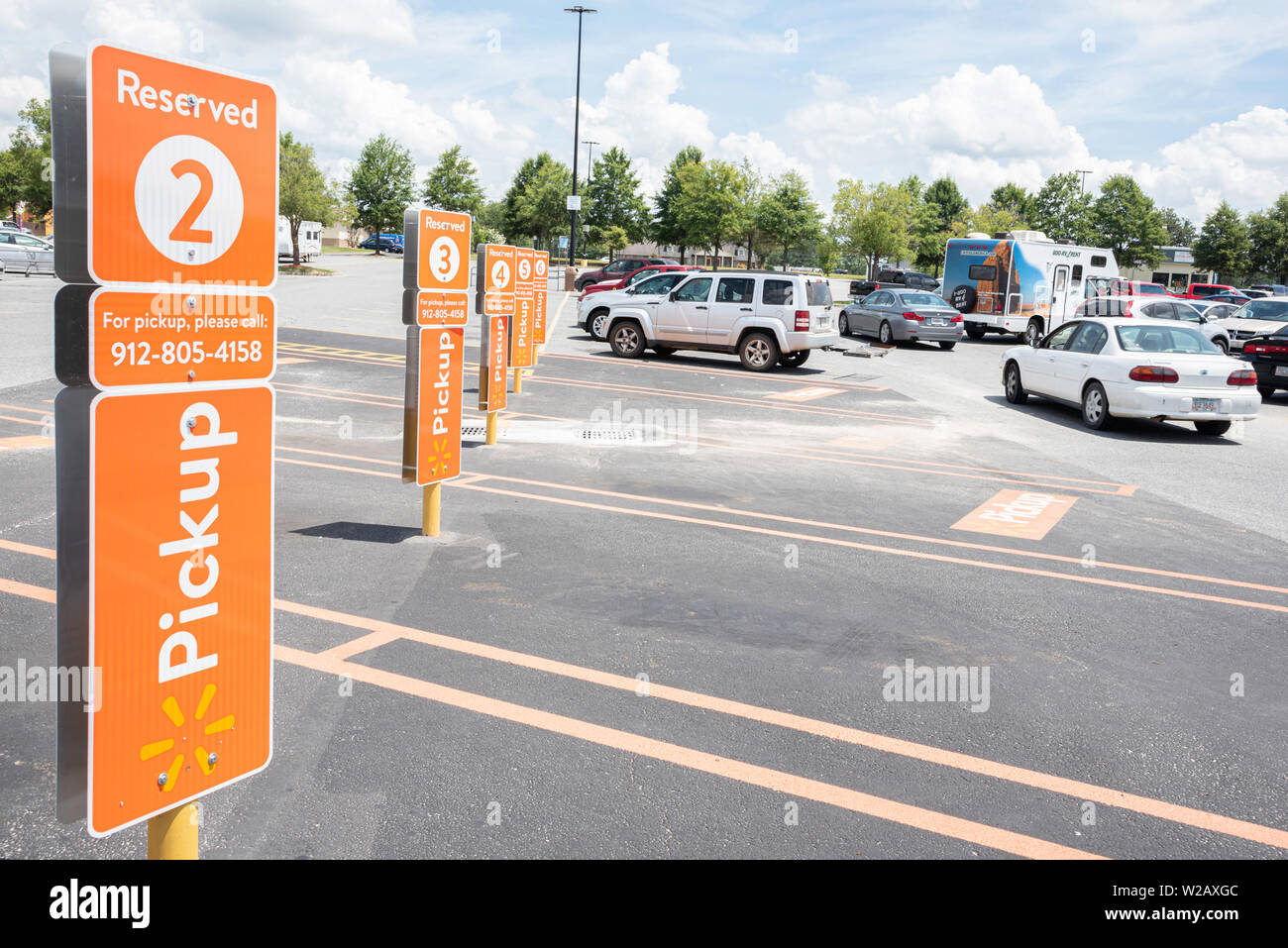Vidalia, Georgia / STATI UNITI D'America - 28 Maggio 2019: i posti auto riservati per Walmart del nuovo servizio di prelievo sono contrassegnati con importanti segni di colore arancione. Foto Stock