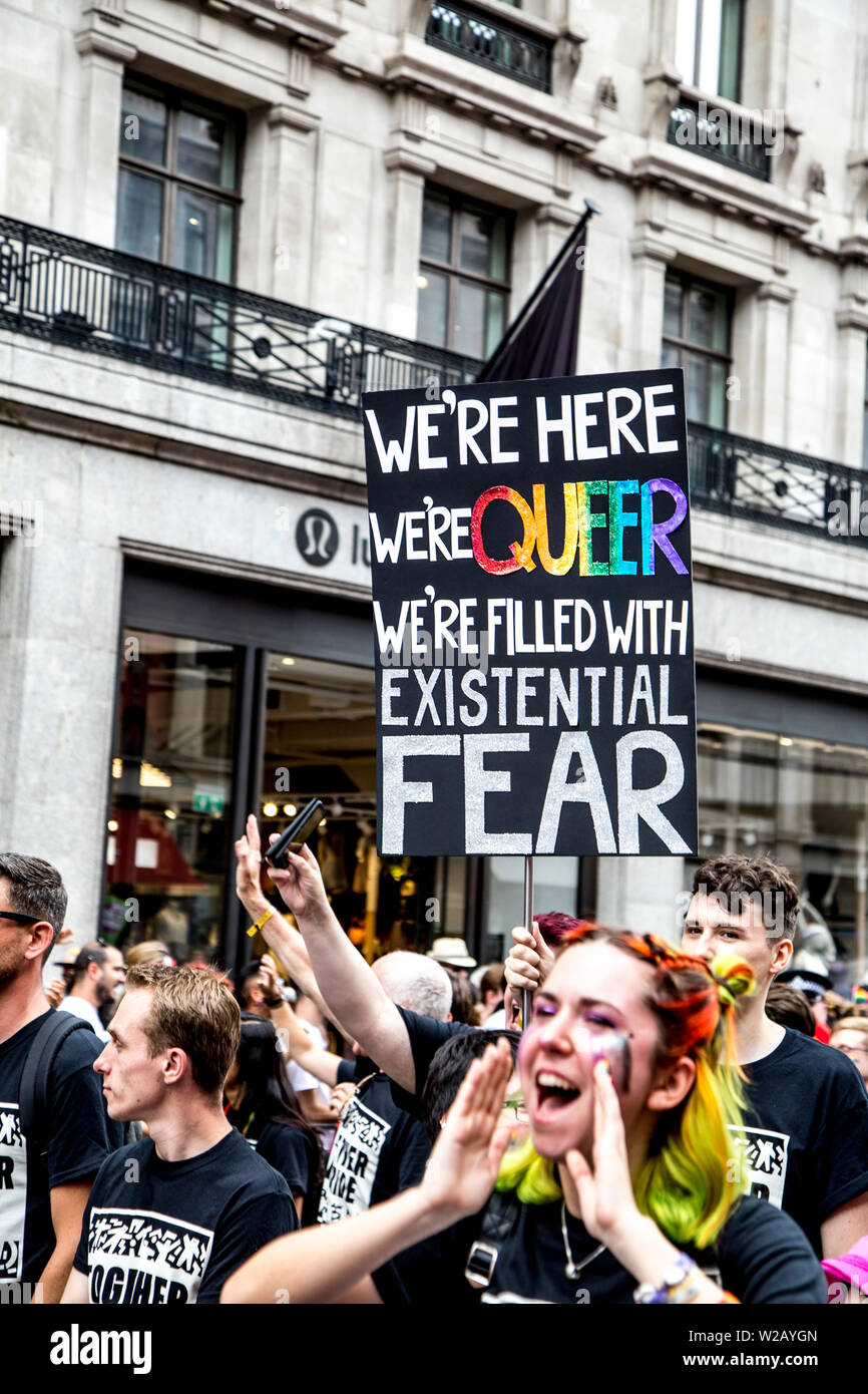 6 Luglio 2019 - segno targhetta dice "Siamo qui, siamo queer, siamo pieni di timore esistenziale', London Pride Parade, REGNO UNITO Foto Stock