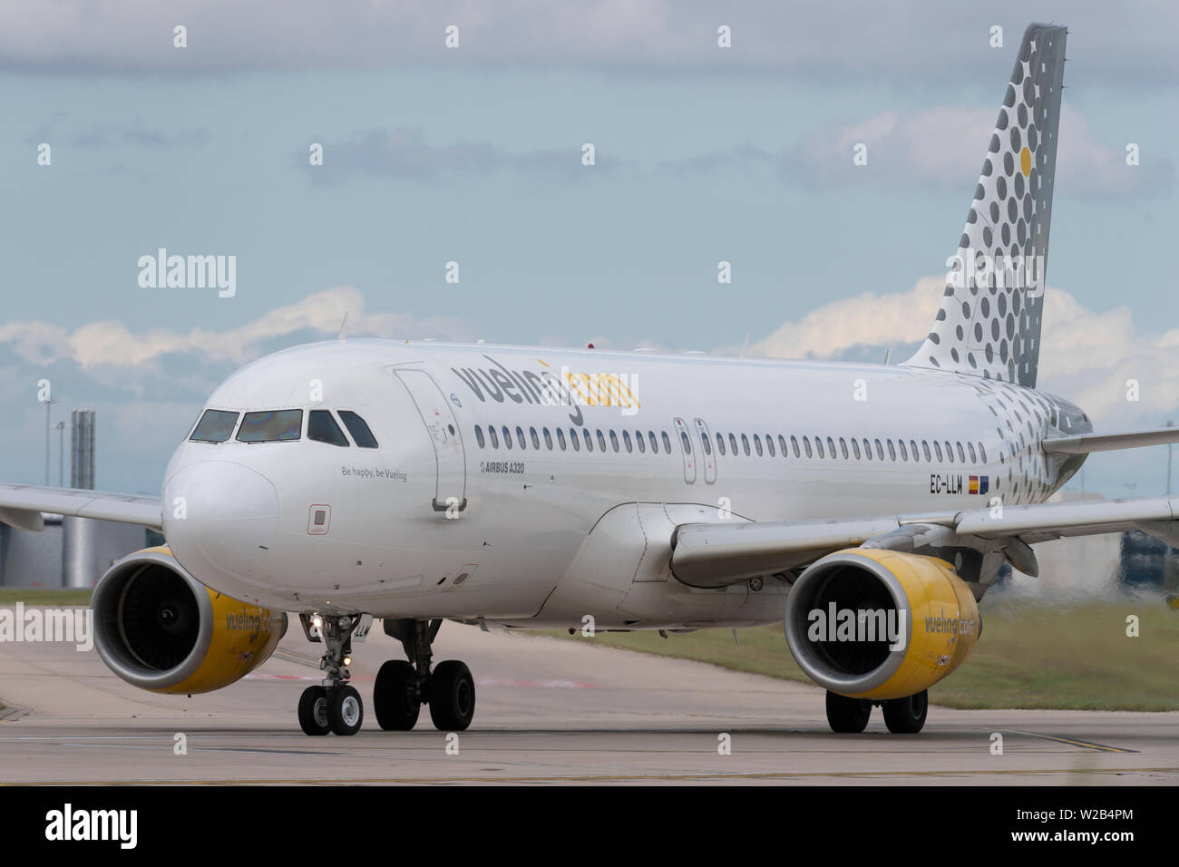 Un Vueling Airbus A320-200 taxi sulla pista dell'aeroporto di Manchester, UK. Foto Stock