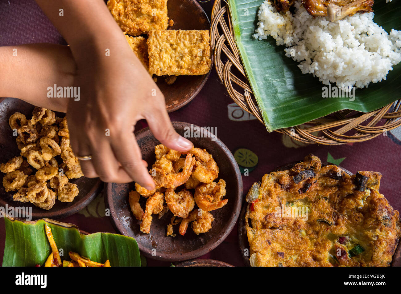 Dall'aspetto gustoso cibo indonesiano servita al tavolo con una varietà di salse, riso, gamberi e pollo e frittata. posa piatto di viaggio e concetto di cibo Foto Stock
