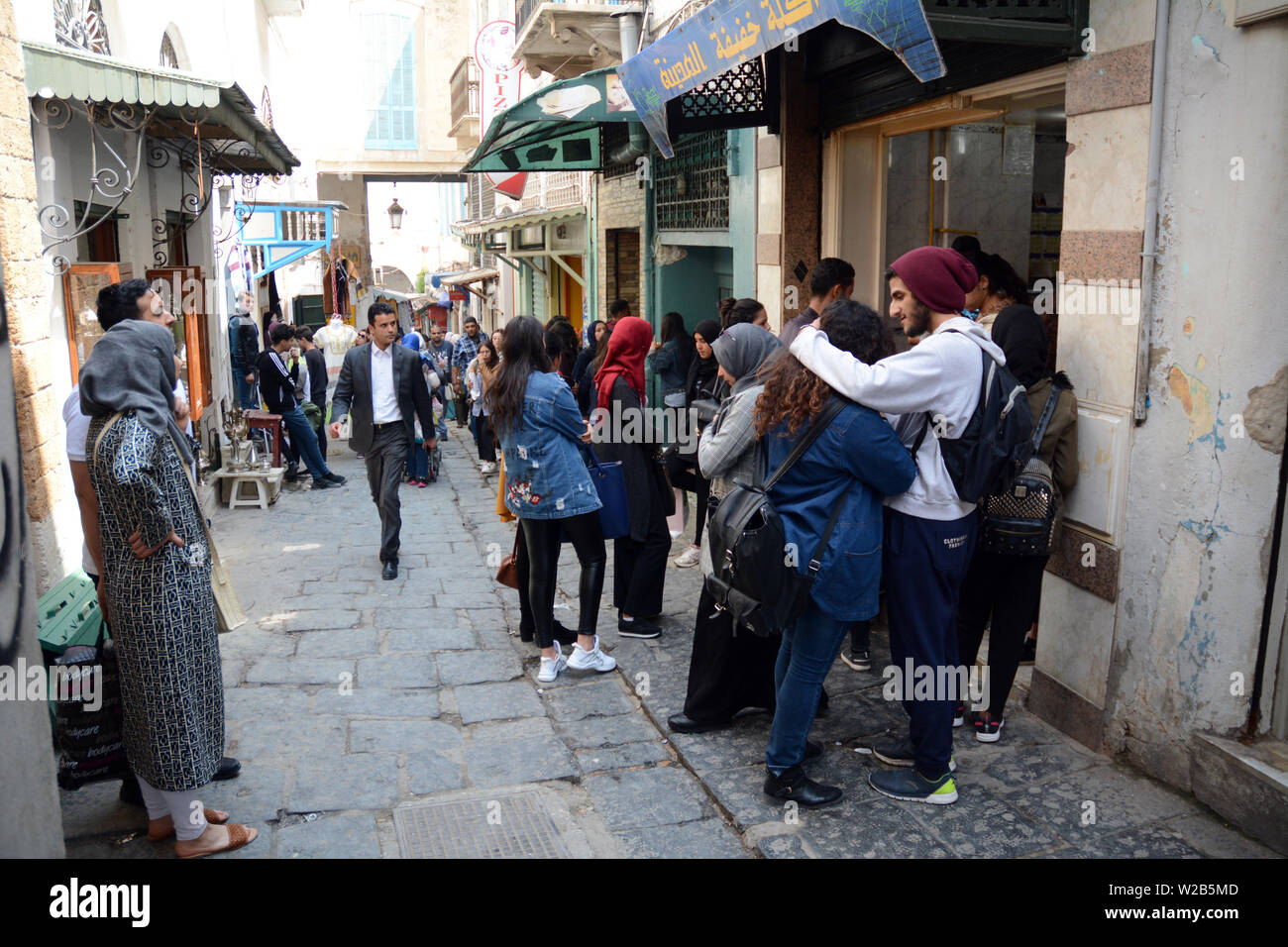 Un gruppo di tunisini su Rue de la Kasbah, un vialetto pedonale nel cuore della medina o città vecchia di Tunisi, Tunisia. Foto Stock
