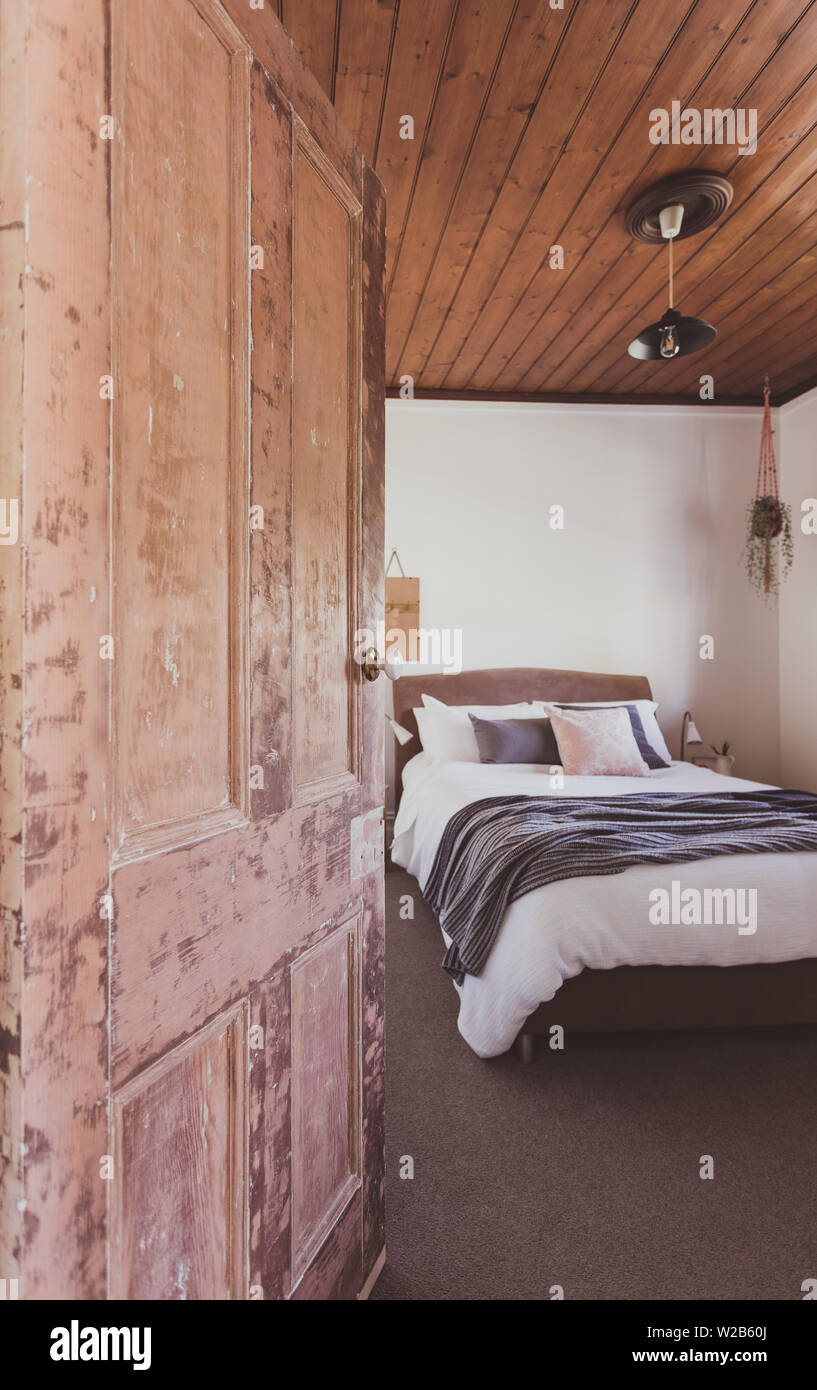 Paese di legname apertura di porta alla camera da letto queen size con baltico massimale di pino Foto Stock