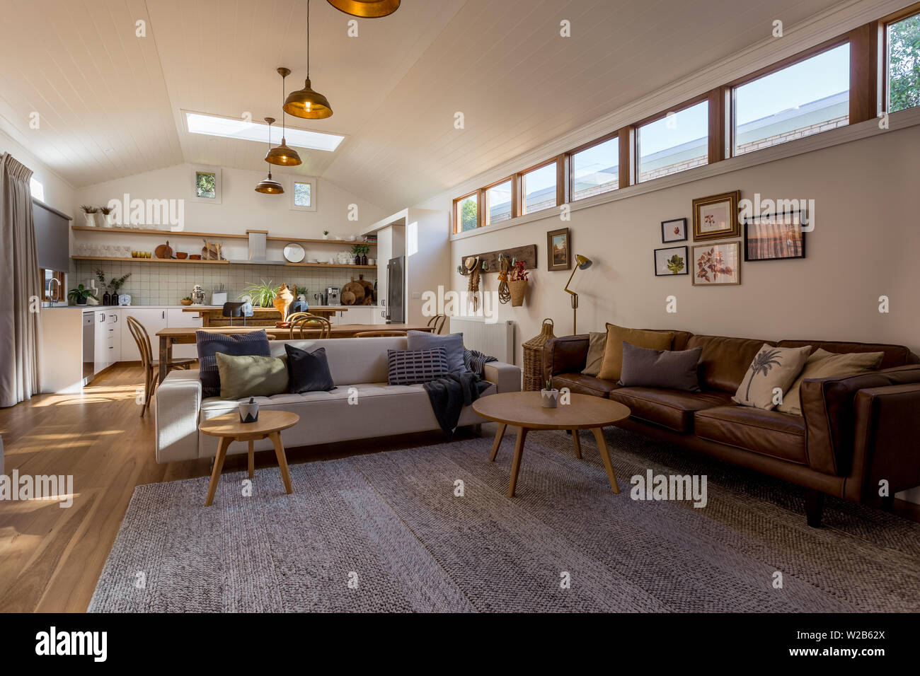 Soggiorno a pianta aperta, cucina e sala da pranzo in una casa di campagna con un soffitto a volta e evidenziare windows Foto Stock Soggiorno a pianta aperta, cucina e sala da pranzo in una casa di campagna con un soffitto a volta e evidenziare windows Foto Stock