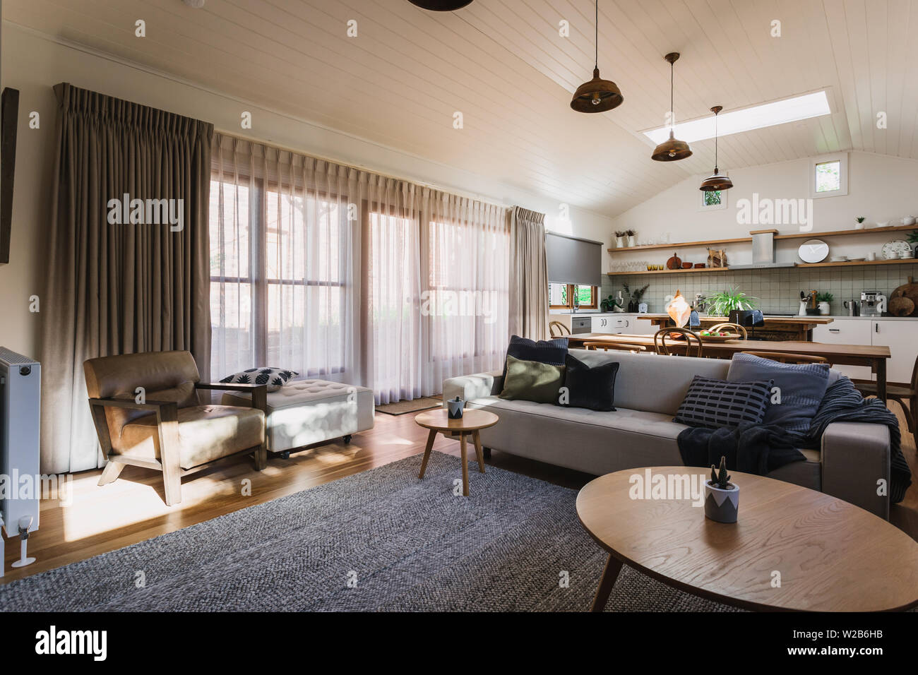 Soggiorno a pianta aperta, cucina e sala da pranzo in una casa di campagna con un soffitto a volta Foto Stock Soggiorno a pianta aperta, cucina e sala da pranzo in una casa di campagna con un soffitto a volta Foto Stock
