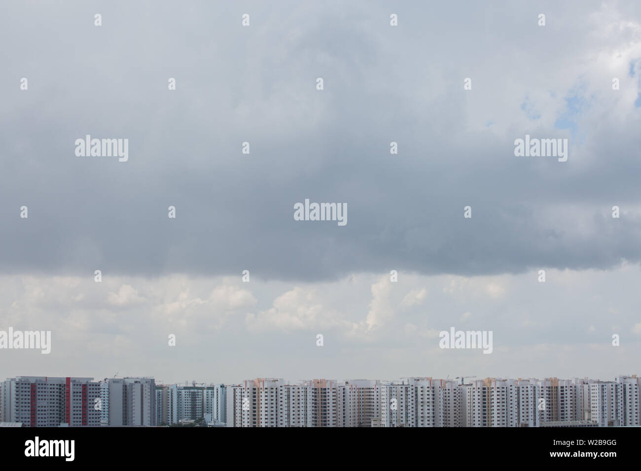 Intensivo di nube spessa è formare fino sul cielo sopra le righe di HDB appartamenti, Singapore. Foto Stock