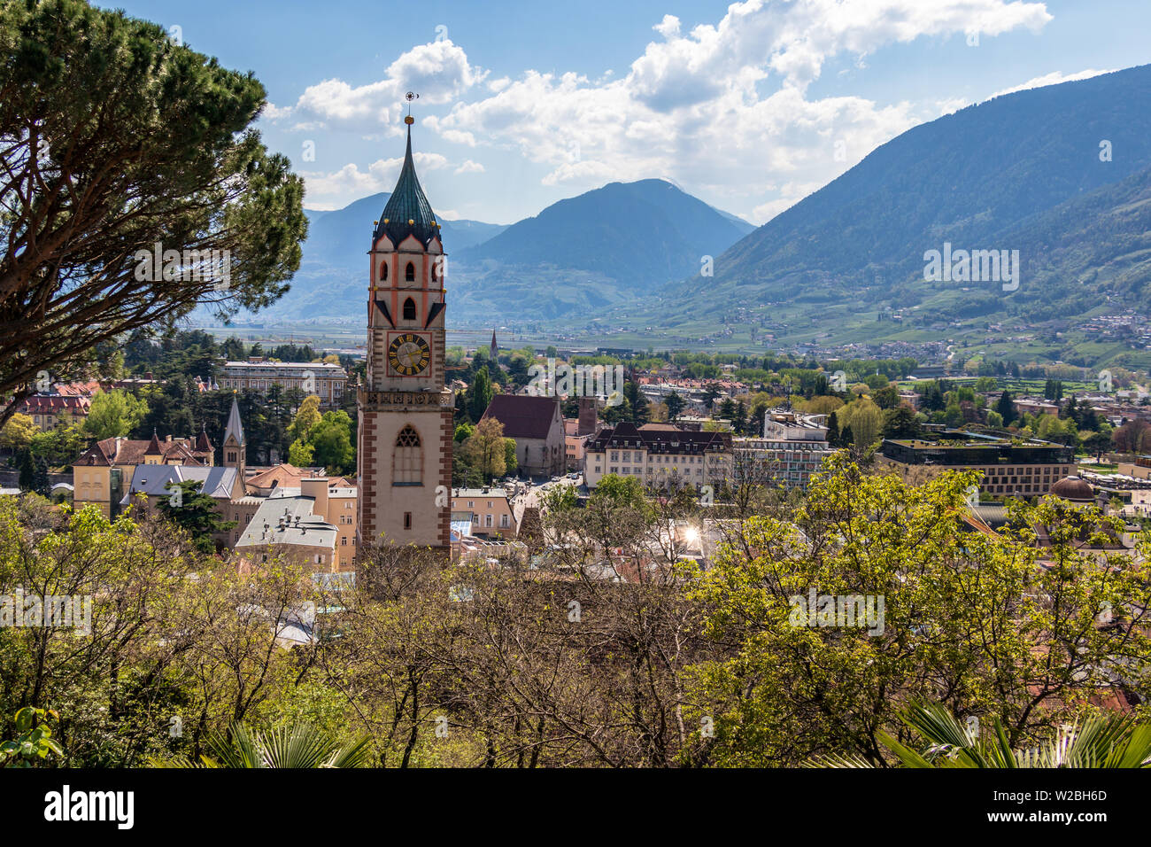 Torre della chiesa cattolica, Sankt Nikolaus Stadtpfarrkirche, con skyline di Merano in background. La città di Merano. Provincia di Bolzano, Alto Adige, Italia. L'Europa. Foto Stock