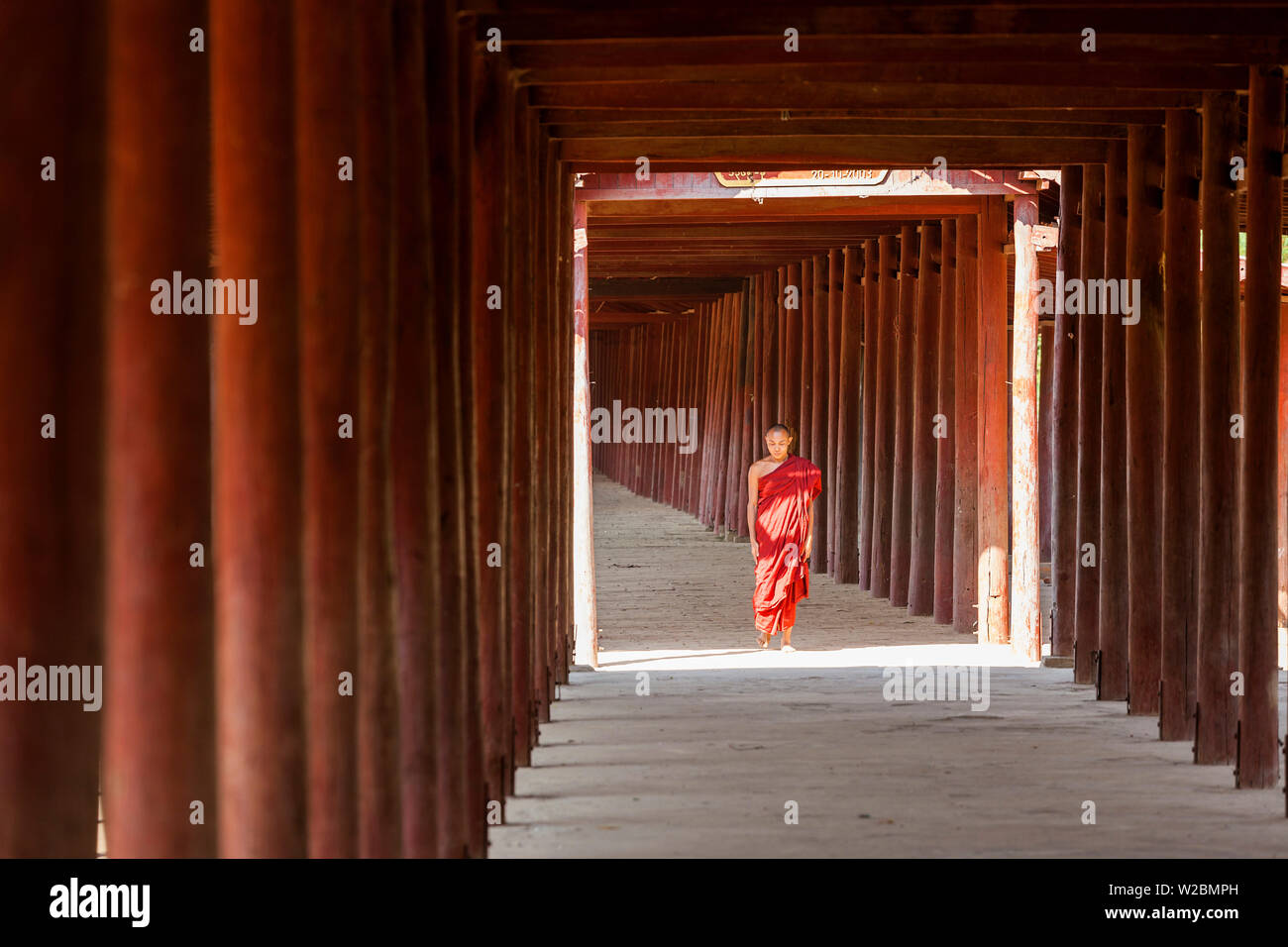 Monaco in passerella di colonne di legno al tempio, Salay, Myanmar (Birmania) Foto Stock