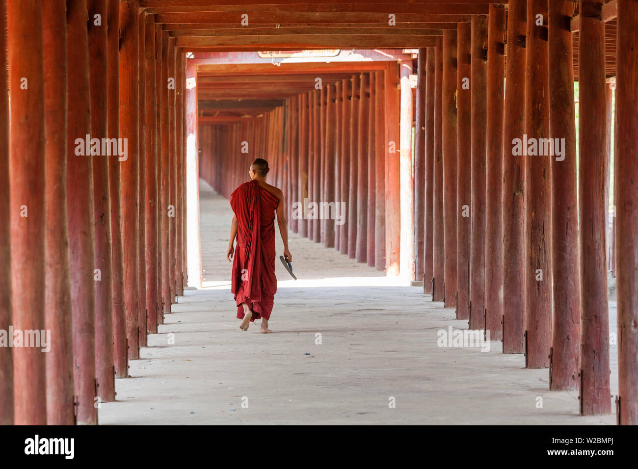 Monaco in passerella di colonne di legno al tempio, Salay, Myanmar (Birmania) Foto Stock