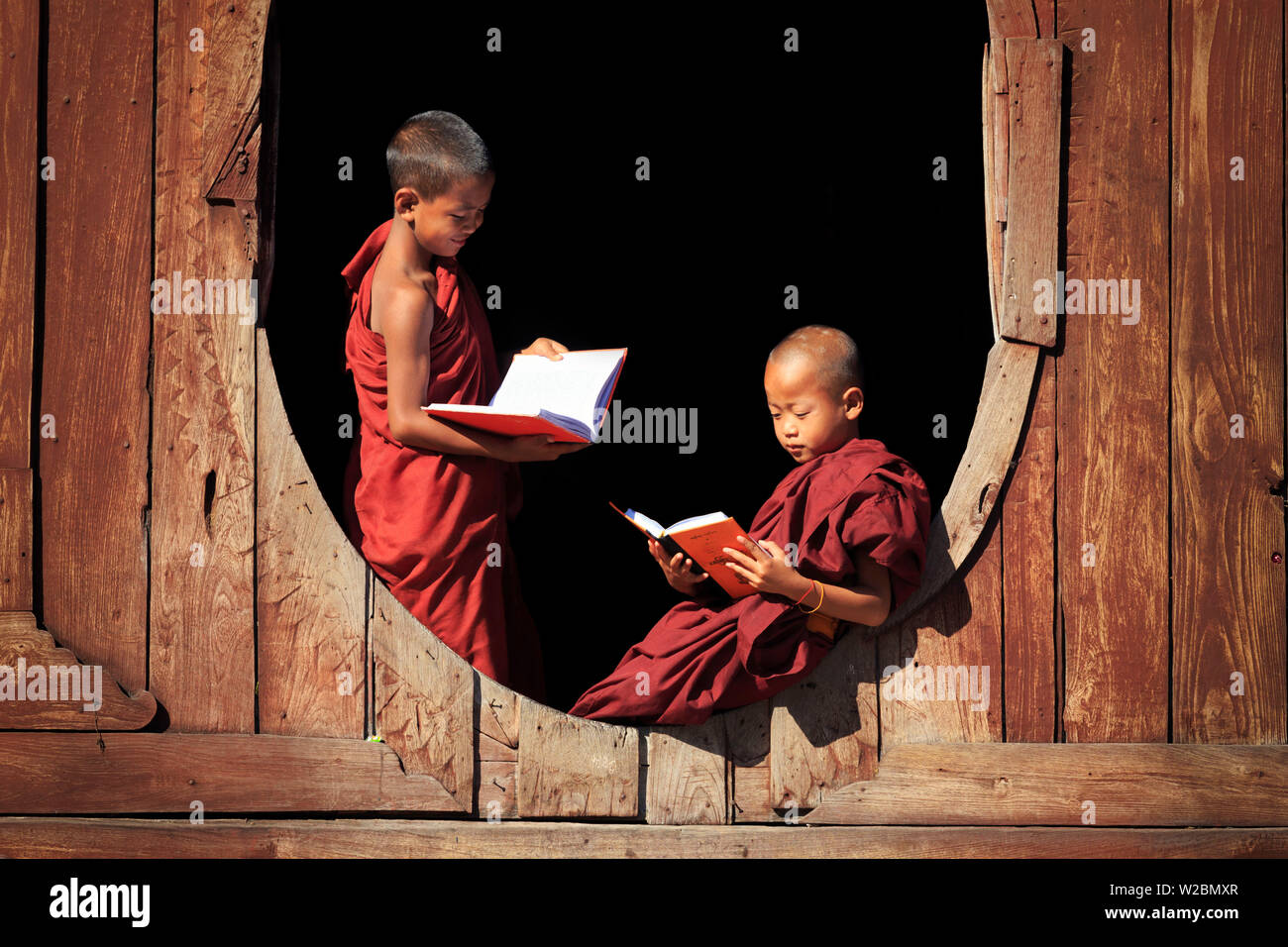 Myanmar (Birmania), Stato Shan, Lago Inle, Nyaungshwe, Shwe Yaunghwe Kyaung monastero monaci novizio da Windows di ordinazione in teak hall Foto Stock