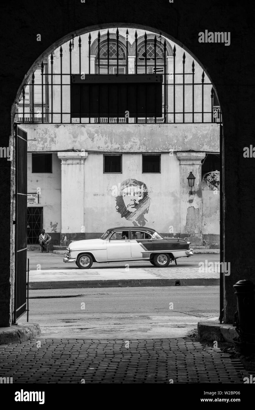 50's Classic American auto passando un murale di Che Guevara, Habana Vieja, Havana, Cuba Foto Stock