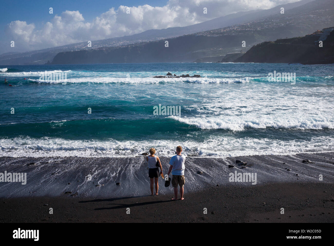 Spagna Isole Canarie, Tenerife, Puerto de la Cruz, persone su Playa Martianez, spiaggia di sabbia nera Foto Stock