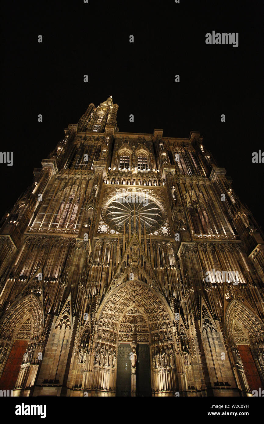 La facciata ovest della cattedrale di Notre Dame a Strasburgo, Francia, illuminata di notte Foto Stock
