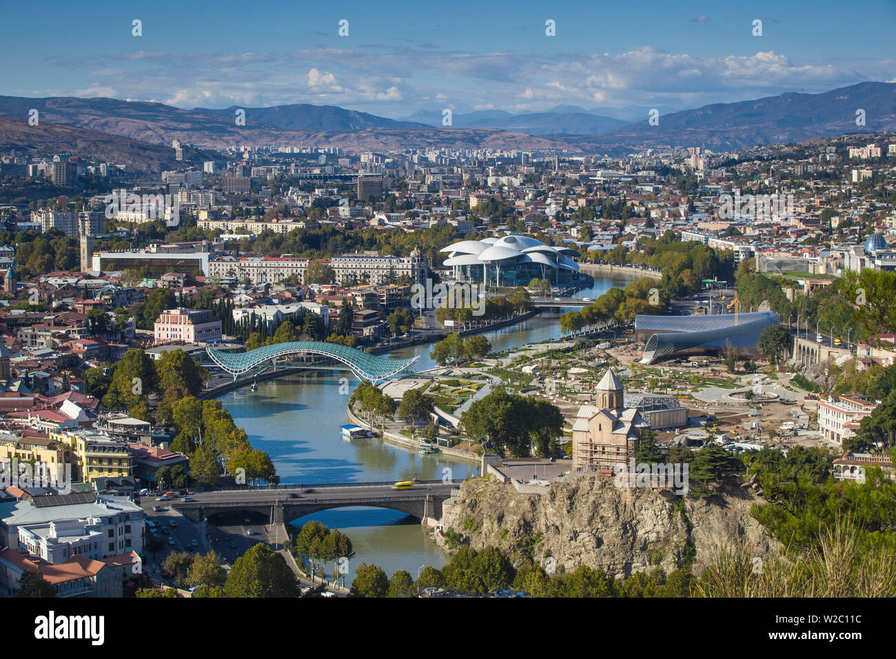 La Georgia, Tbilisi, vista di Tbilisi guardando verso il ponte di Metekhi e Chiesa, ponte di pace e il servizio pubblico edificio sulla destra Rike Park il teatro e la sala espositiva Foto Stock