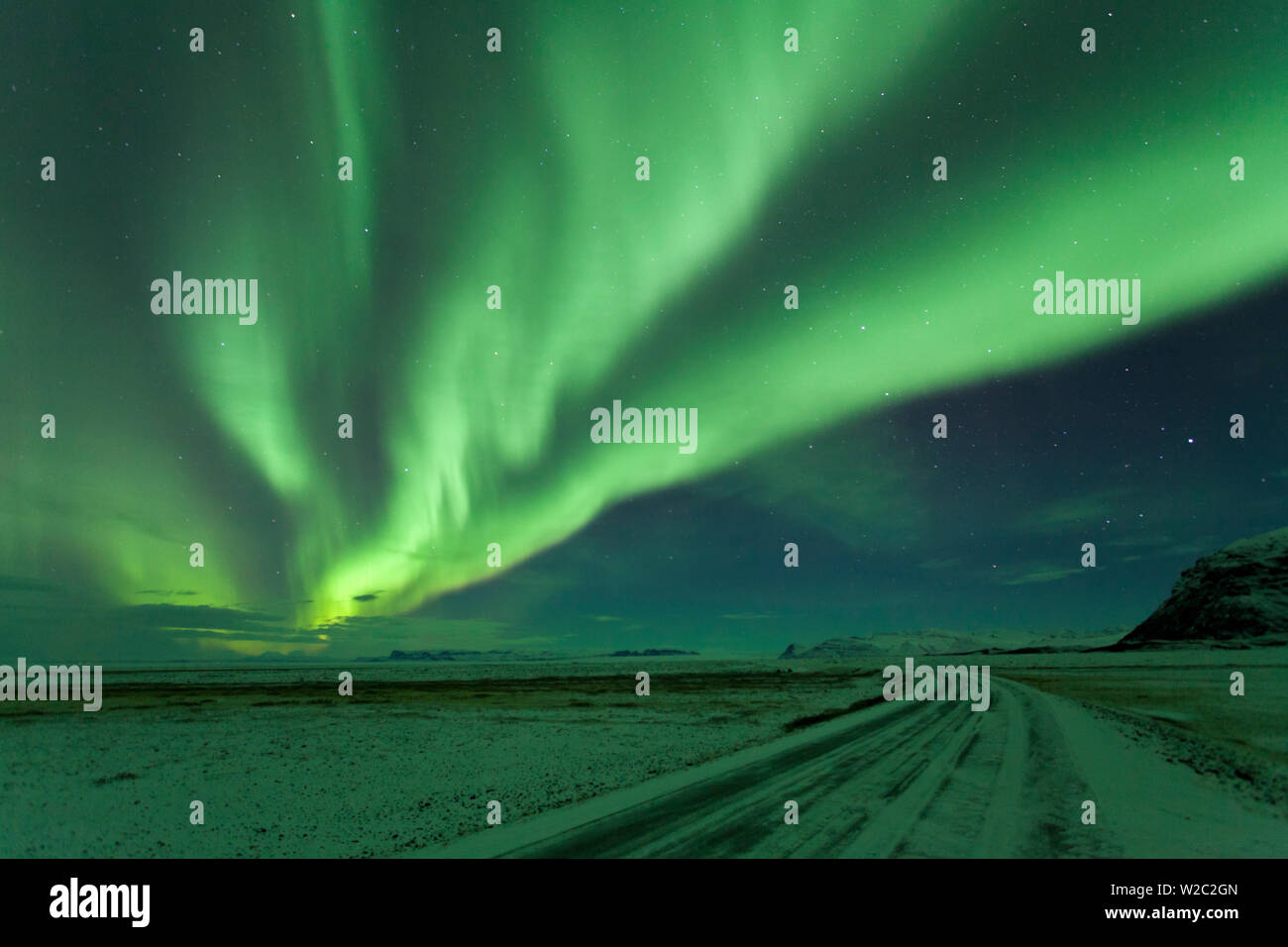 Luci del nord, Aurora Boreale, strada invernale con neve, Islanda Foto Stock