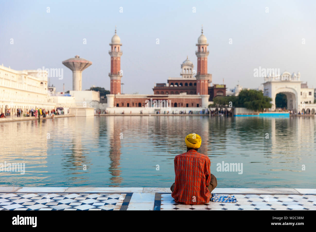 India Punjab, Amritsar e Pellegrino seduto di fronte all'Harmandir Sahib, noto come il Tempio d'Oro Foto Stock