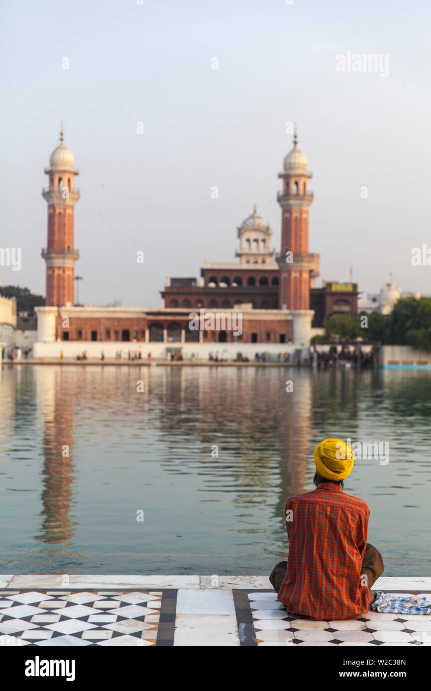 India Punjab, Amritsar e Pellegrino seduto di fronte all'Harmandir Sahib, noto come il Tempio d'Oro Foto Stock