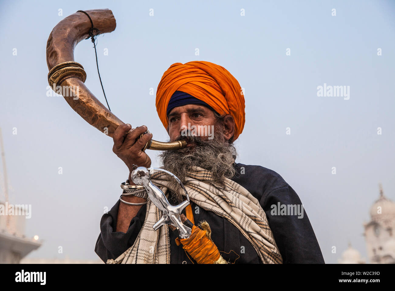 India Punjab, Amritsar e pellegrino soffia lo strumento musicale all'Harmandir Sahib, noto come il Tempio d'Oro Foto Stock