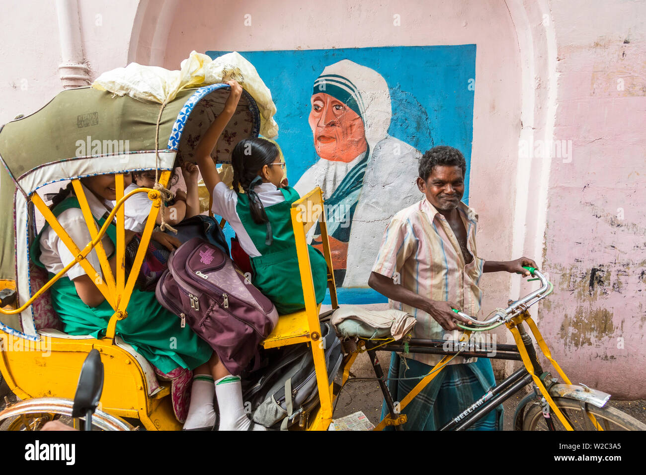 La scuola dei bambini in ciclo-rickshaw, con Madre Teresa murale, Chennai (Madras), India Foto Stock