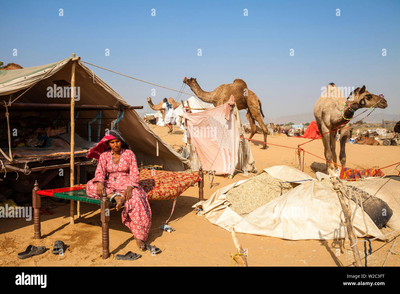 India Rajasthan, Pushkar, Pushkar Camel Fair, una donna seduta fuori dalla sua tenda Foto Stock