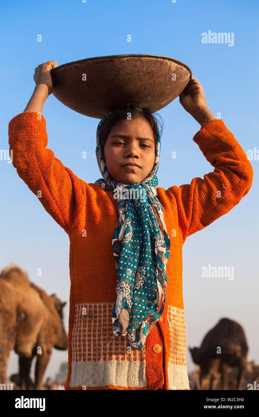 India Rajasthan, Pushkar, Pushkar Camel Fair, ragazza off per la raccolta di escrementi di cammello Foto Stock