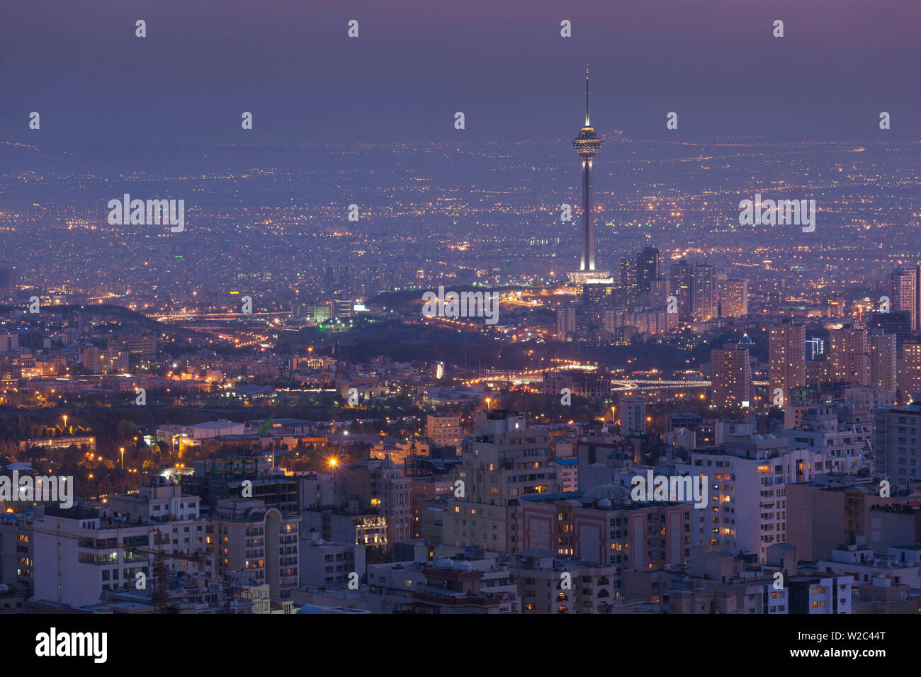 Iran, Teheran, elevati dello skyline della città con vista tfrom il tetto dell'Iran Park verso la torre di Milad, crepuscolo Foto Stock