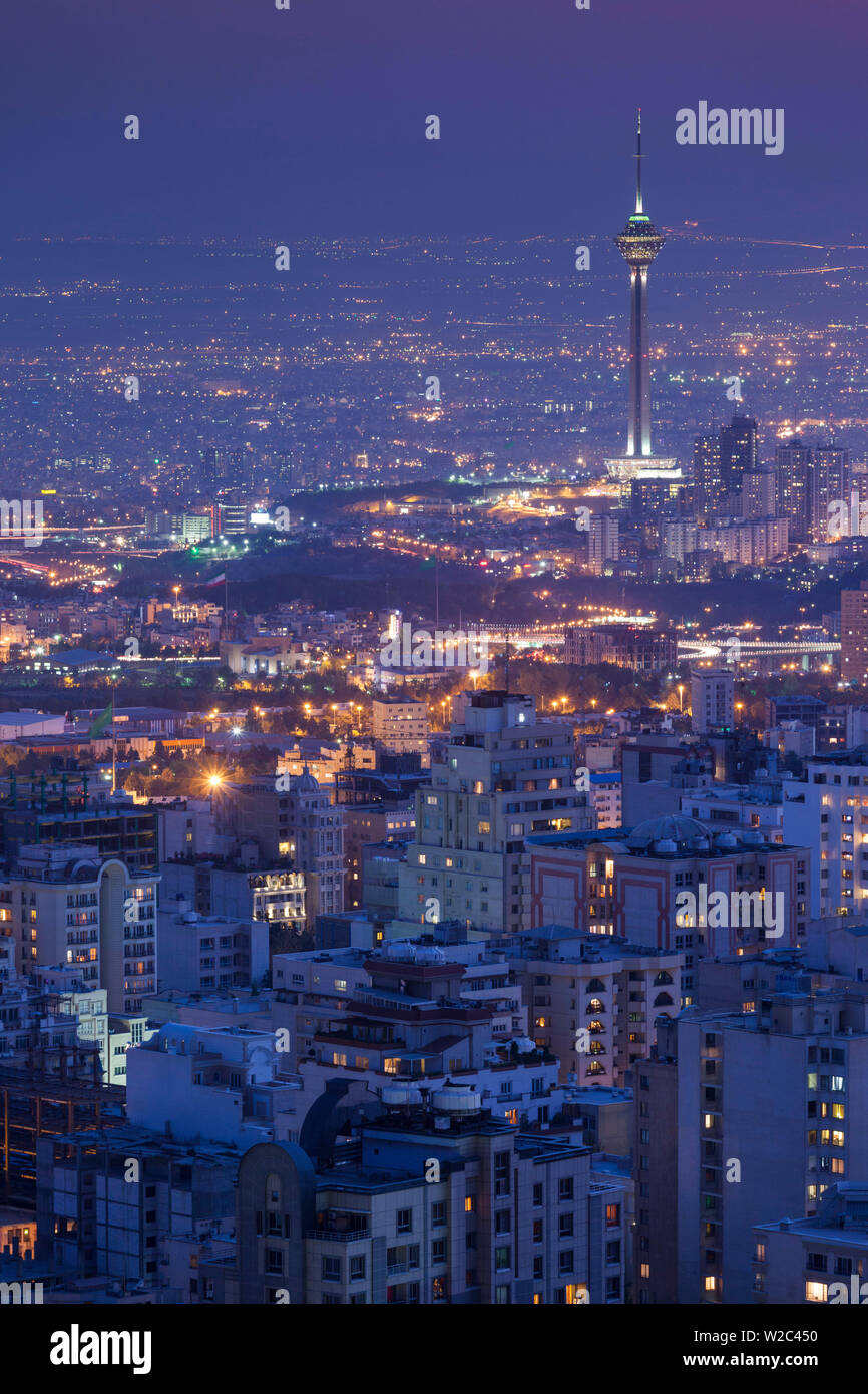 Iran, Teheran, elevati dello skyline della città con vista tfrom il tetto dell'Iran Park verso la torre di Milad, crepuscolo Foto Stock