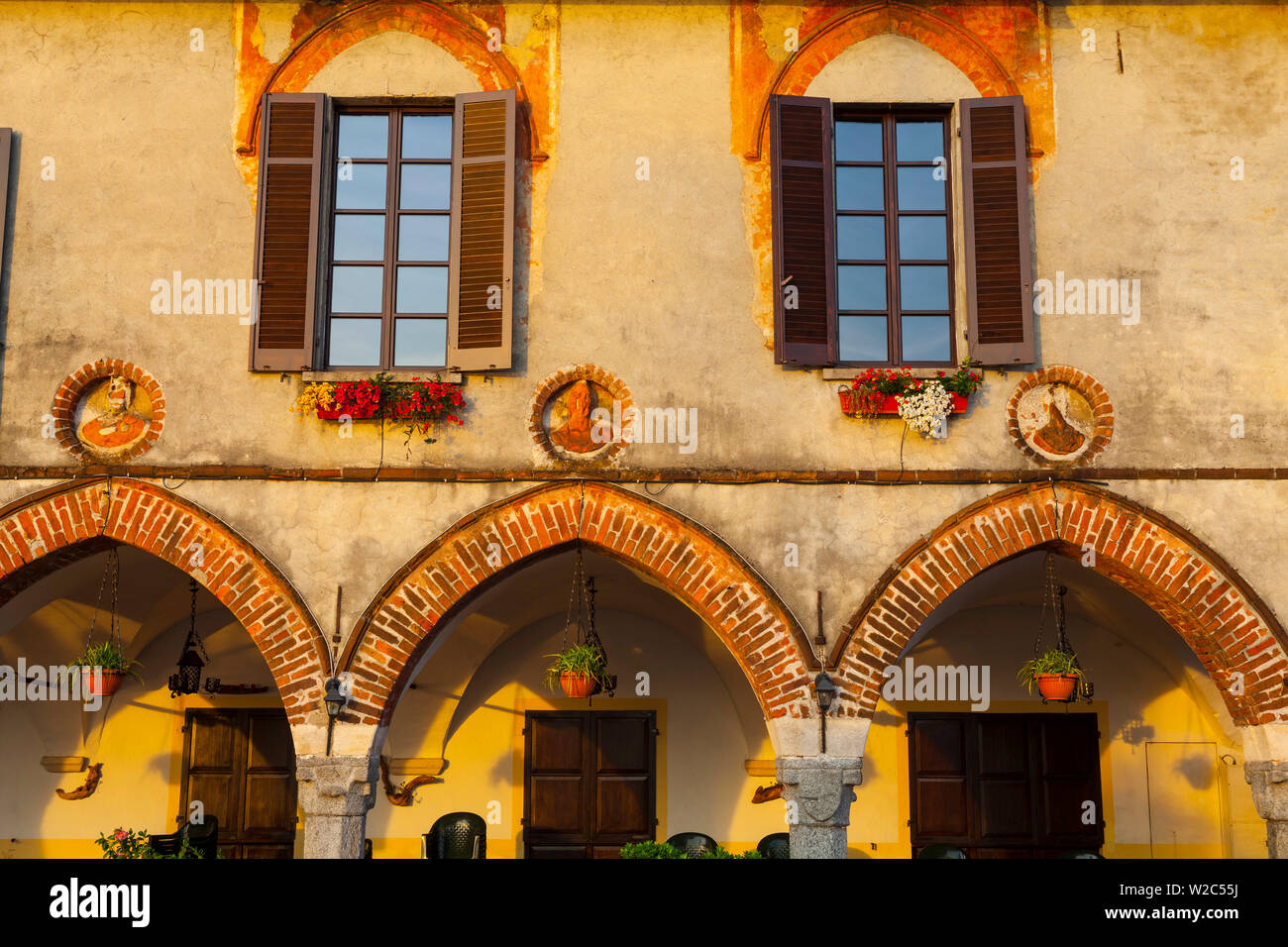 Città vecchia facciata di edificio illuminata di sunrise, Arona, Lago Maggiore, Piemonte, Italia Foto Stock
