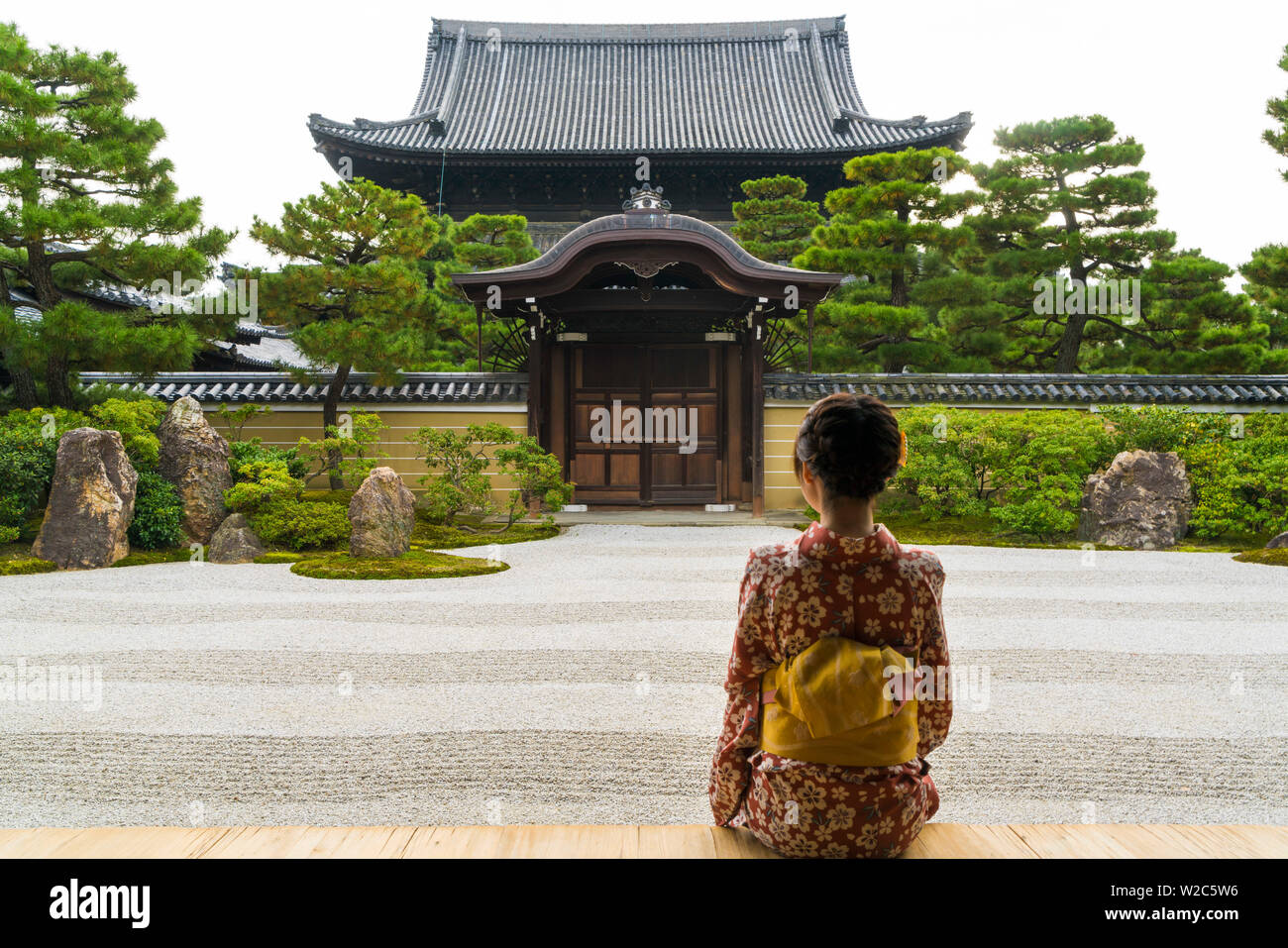 Donna che guarda sul giardino Zen, Kyoto, Giappone Foto Stock