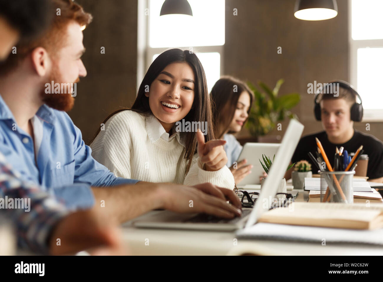 Gli studenti universitari utilizzando laptop in biblioteca, studiare Foto Stock