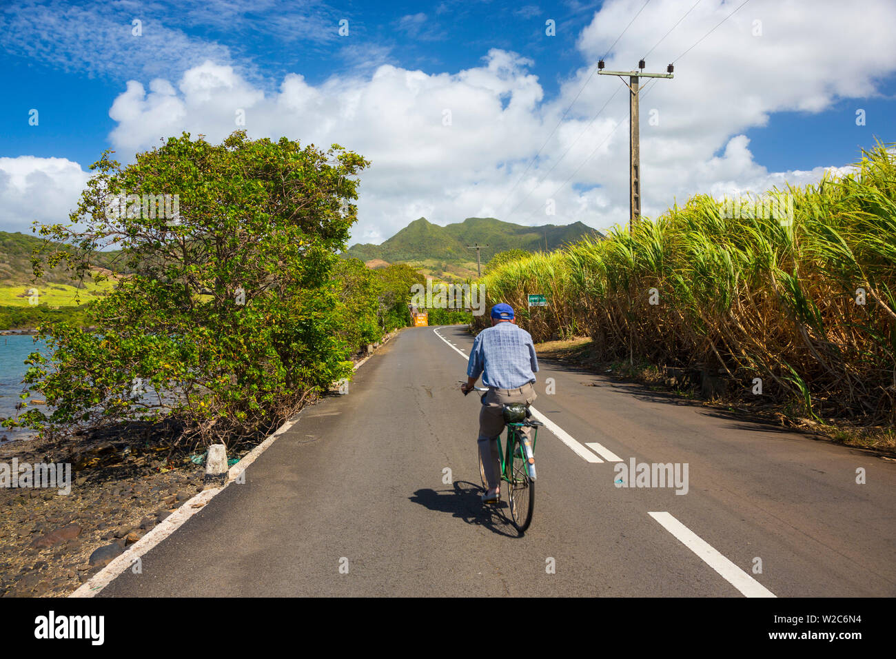 Uomo in bicicletta lungo una strada, Grand Port District, East Coast, Mauritius Foto Stock