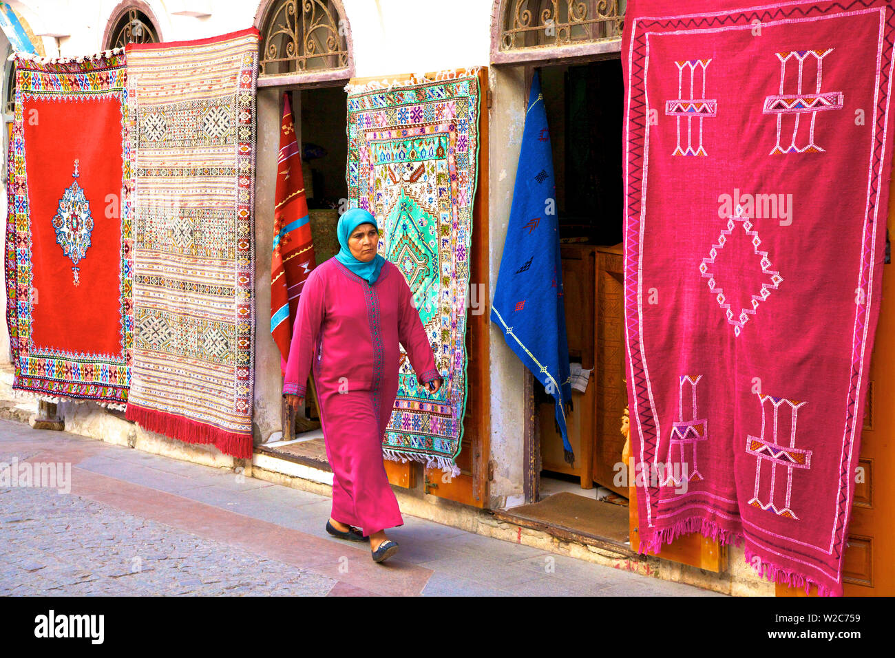 Persona passata a piedi negozio di tappeti, la Medina, Rabat, Marocco, Africa del Nord Foto Stock