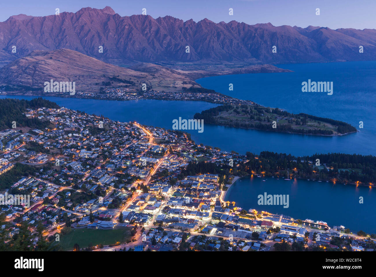 Nuova Zelanda, Isola del Sud, Otago, Queenstown, elevati vista città con il Remarkables dal Skyline Gondola deck, crepuscolo Foto Stock