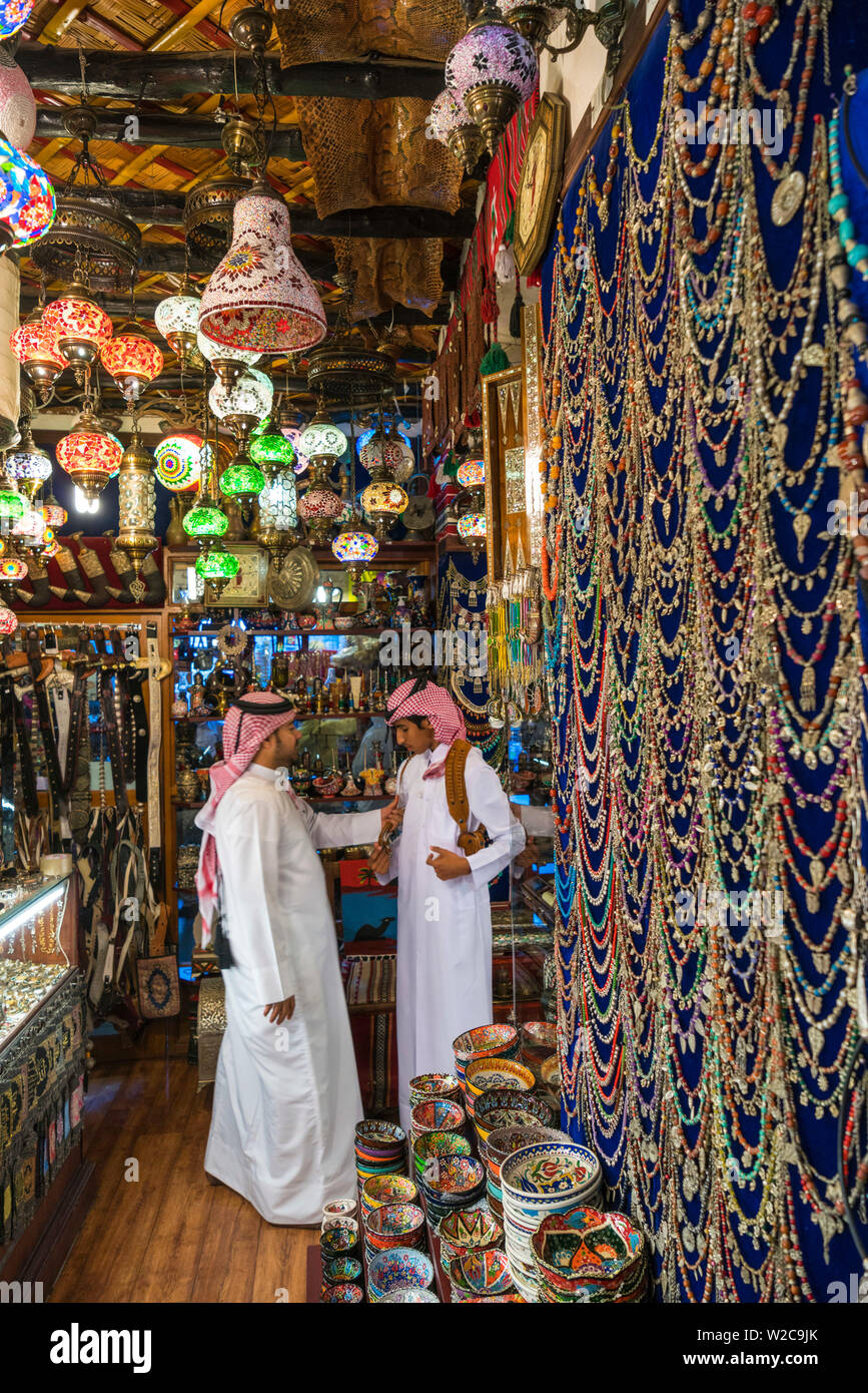 Due uomini arabi in negozio di vendita lampade Arabo, gioielli, oggetti in ceramica e souvenir, Doha, Qatar Foto Stock