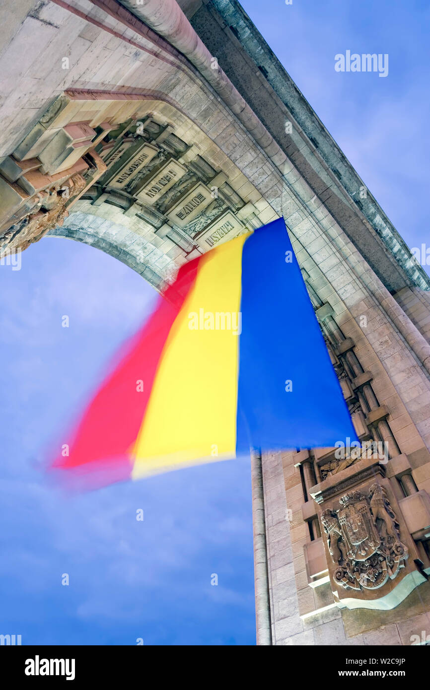 L'Europa, Romania, Bucarest, Arco Trionfale (Arcul de Triumf) e bandiera rumena illuminata di notte Foto Stock