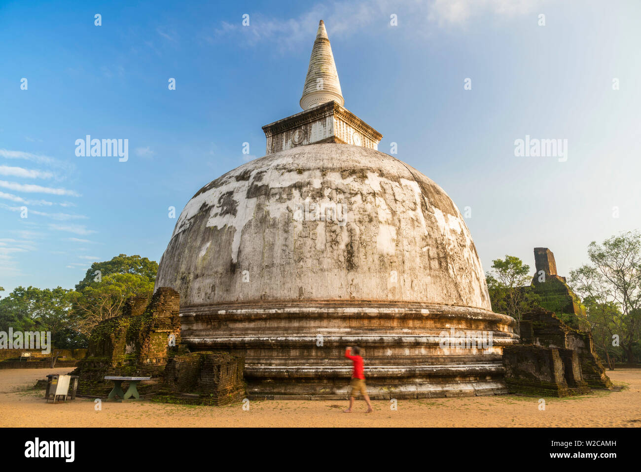 Uomo che cammina intorno Stupa antica città di Polonnaruwa, Sito Patrimonio Mondiale dell'UNESCO, Nord provincia centrale, Sri Lanka Foto Stock