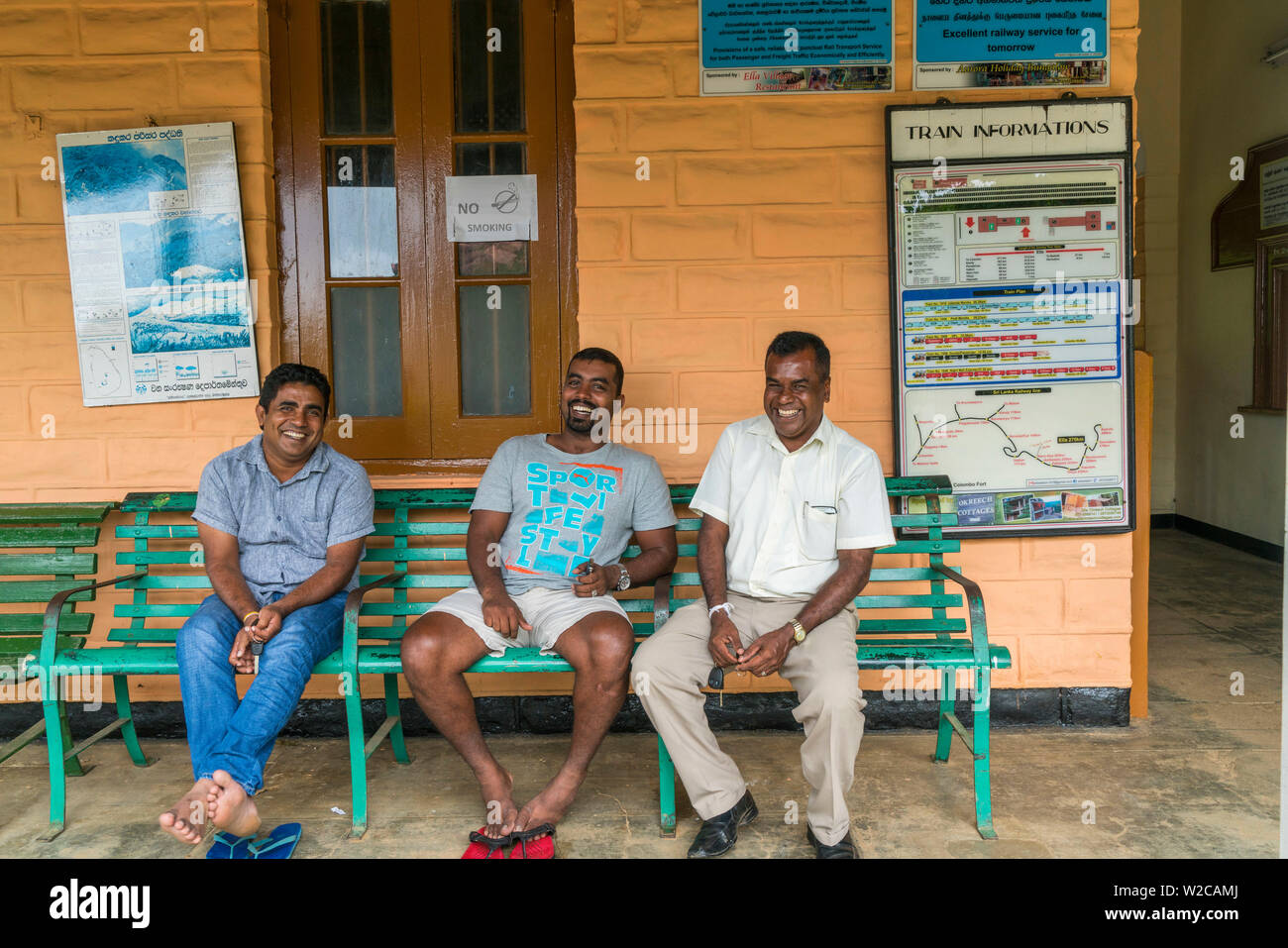 Tre locali sorridente in attesa in corrispondenza ella stazione ferroviaria, Southern Highlands, Sri Lanka Foto Stock
