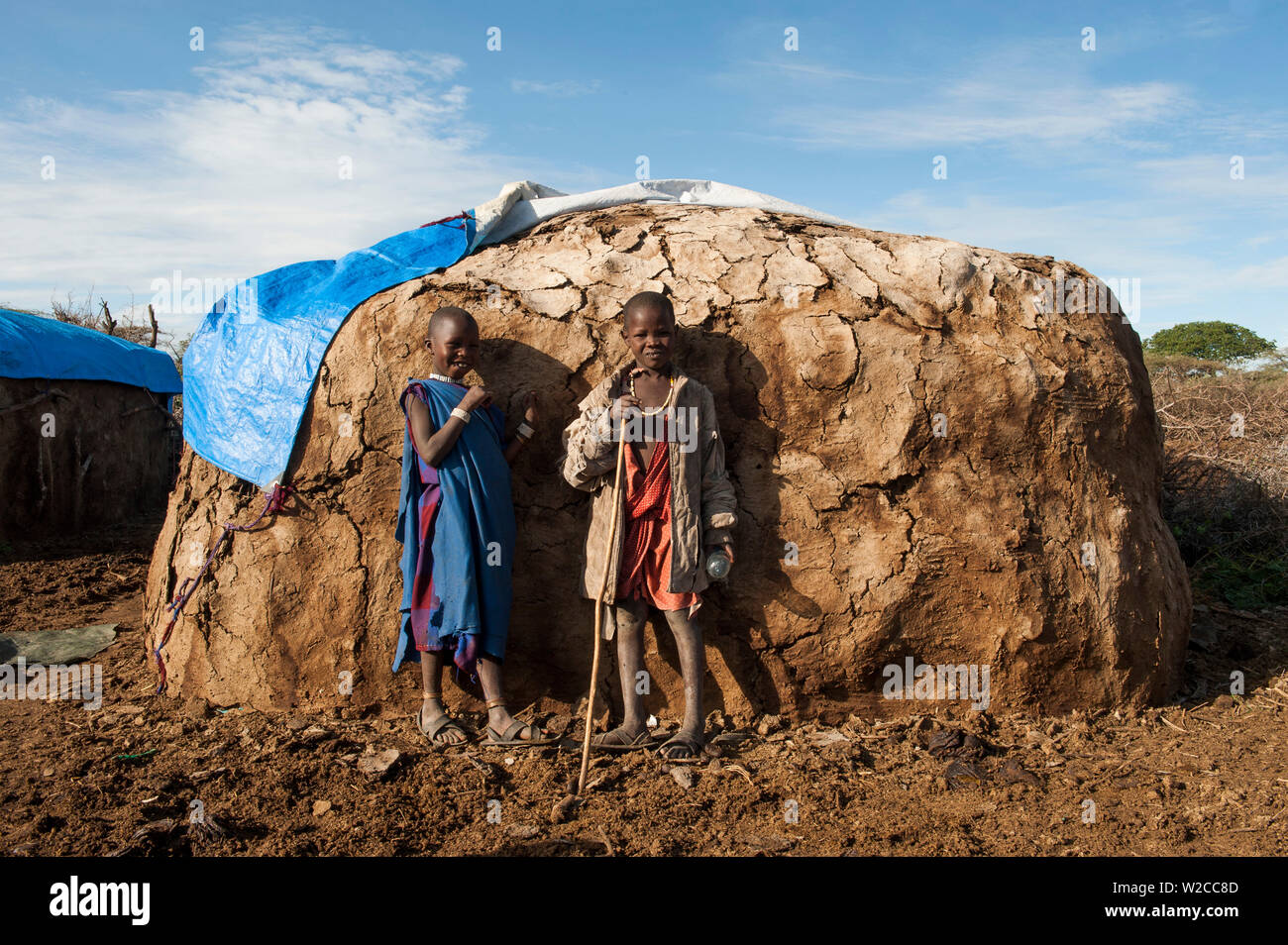 Bambini Maasai staning davanti alla loro capanna di fango o boma, Loliondo, Tanzania Foto Stock