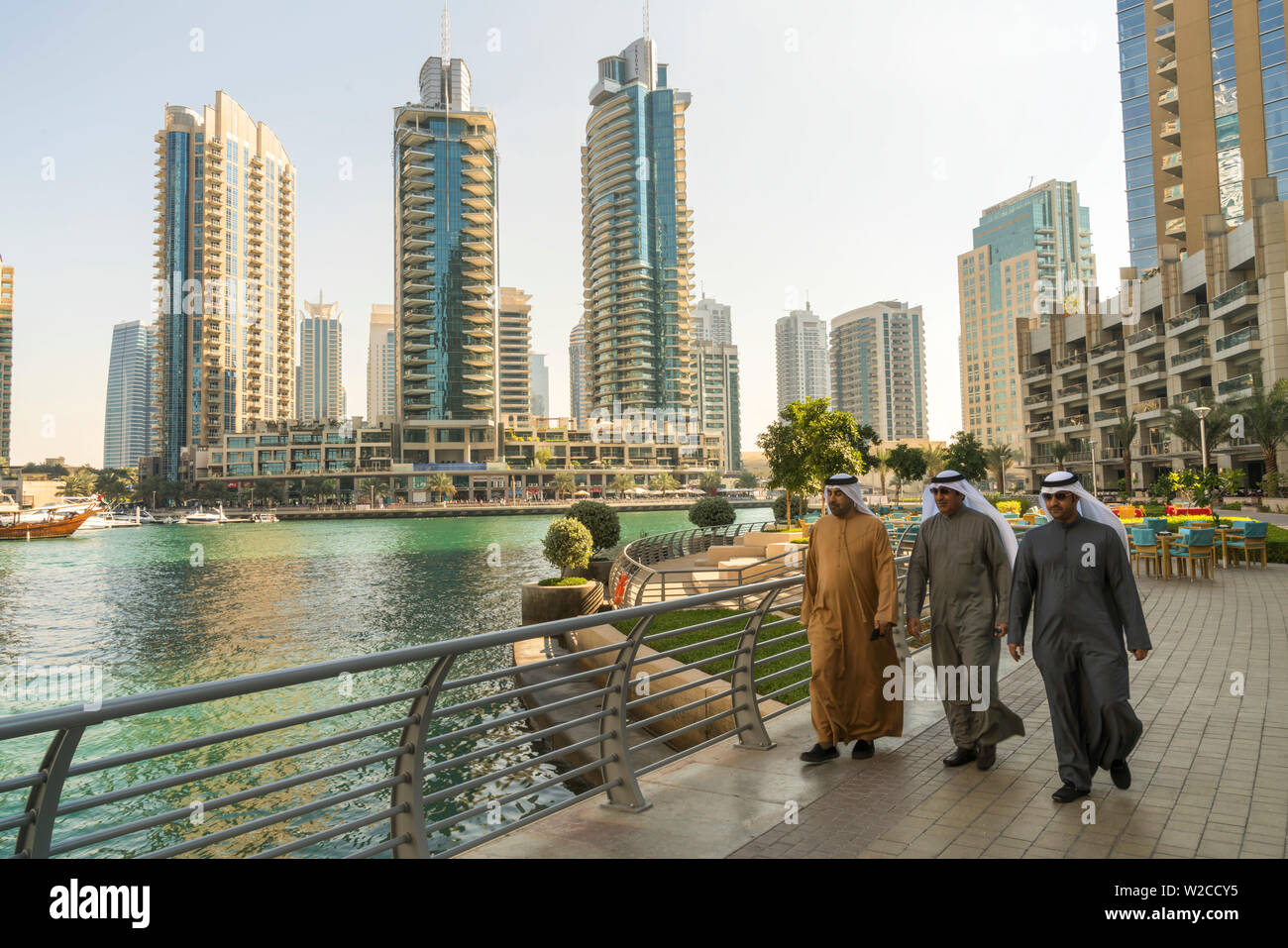 Arabo gli uomini camminare lungo la Promenade, Porticciolo turistico di Dubai Emirati Arabi Uniti, U.A.E Foto Stock
