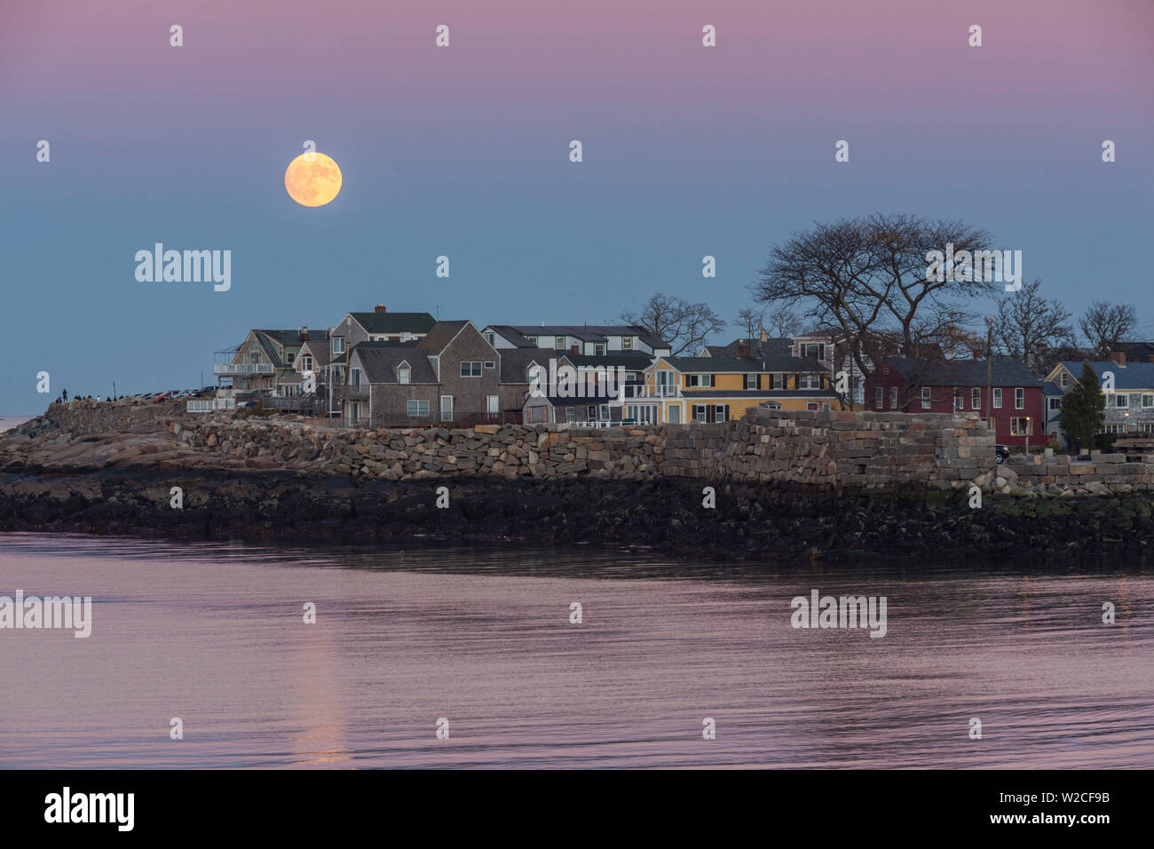 Stati Uniti d'America, Massachusetts, Cape Ann, Rockport, sorgere della luna su edifici sul collo Bearskin, crepuscolo Foto Stock