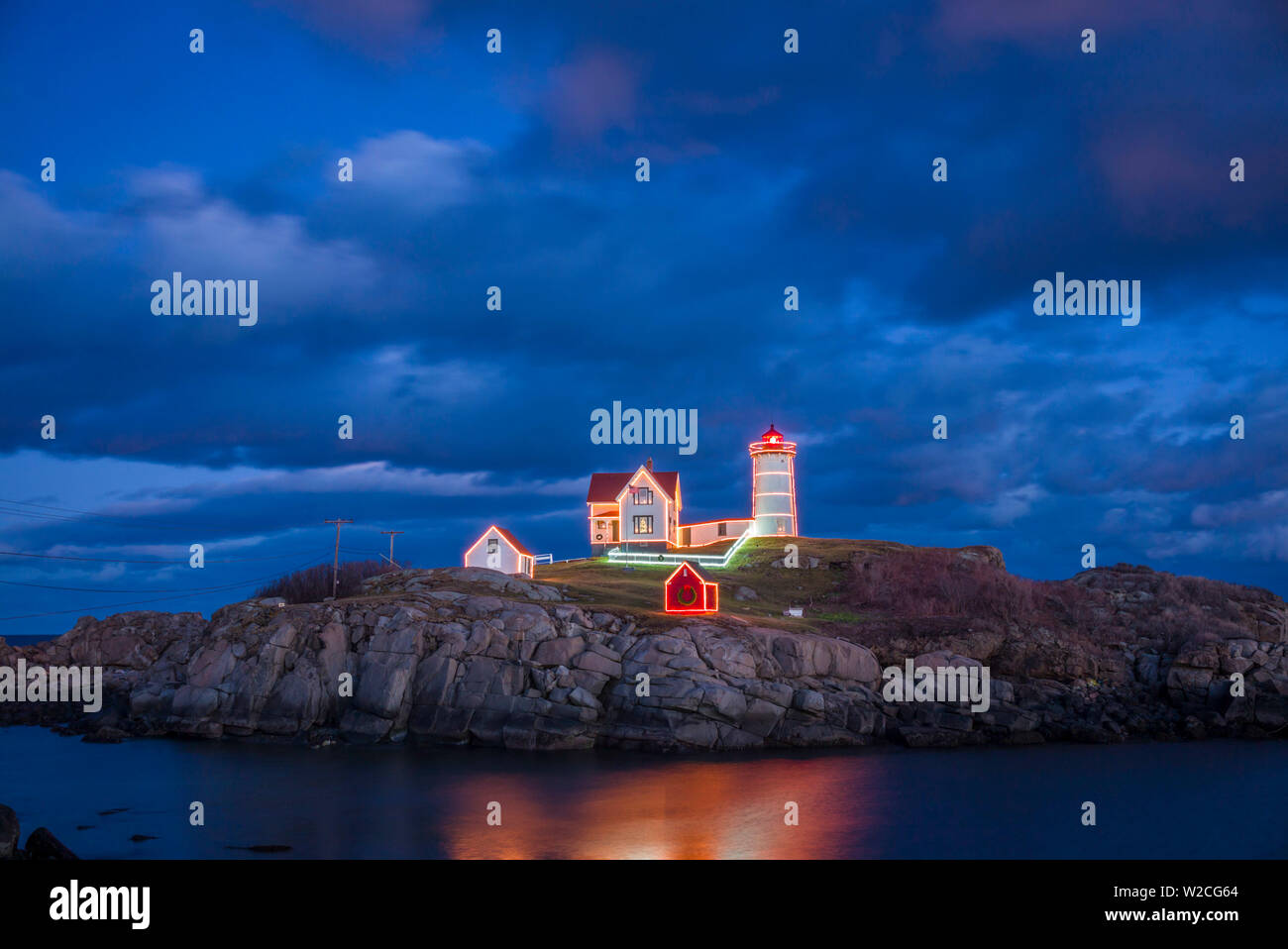 Stati Uniti d'America, Maine, York Beach, Nubble Luce faro con decorazioni di Natale, crepuscolo Foto Stock