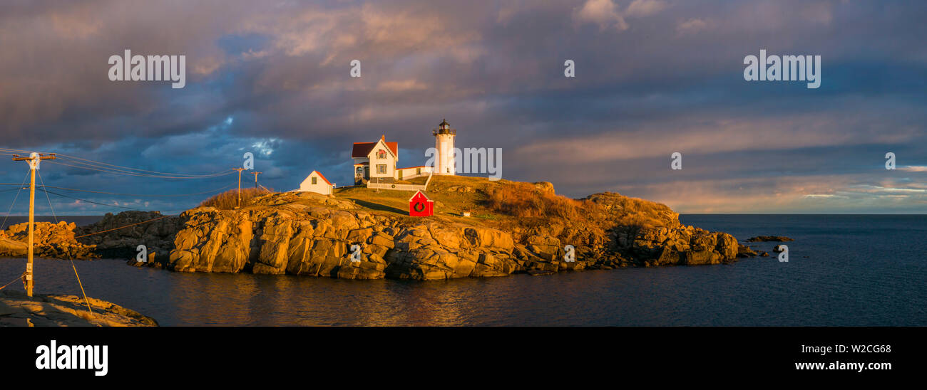 Stati Uniti d'America, Maine, York Beach, Nubble Luce faro con decorazioni di Natale, sunset Foto Stock