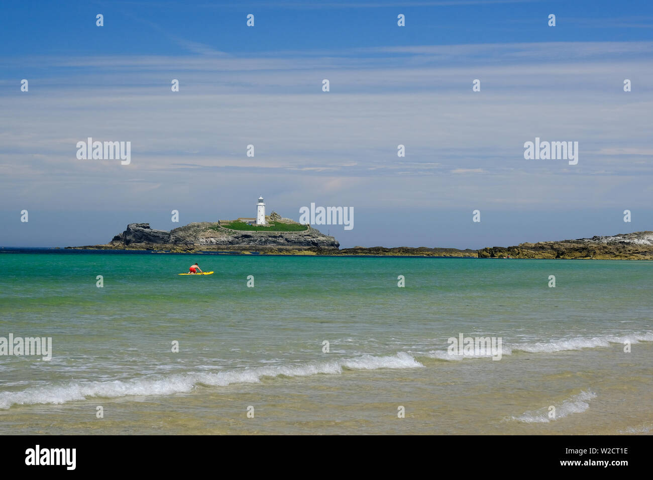 Bagnino di salvataggio su paddleboard in acqua da Godrevy lighthouse sulla costa della Cornovaglia Foto Stock
