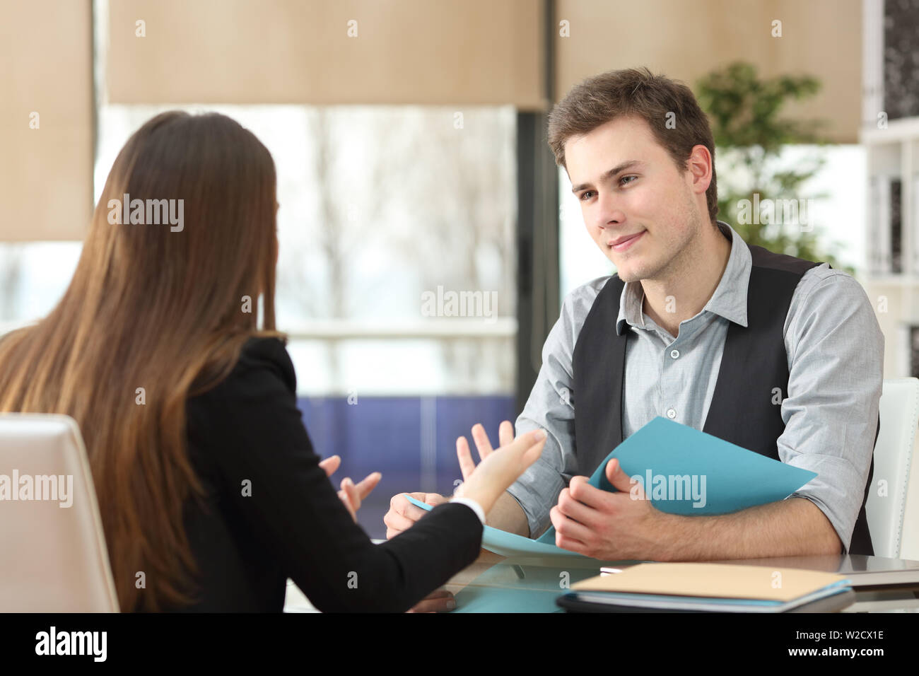 Imprenditore e la donna avente un'intervista seduto presso l'ufficio. I colloqui di donna e uomo ascolta Foto Stock