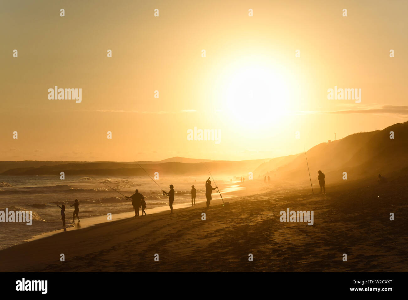 La pesca di famiglia su un tramonto sulla spiaggia di pomeriggio Foto Stock