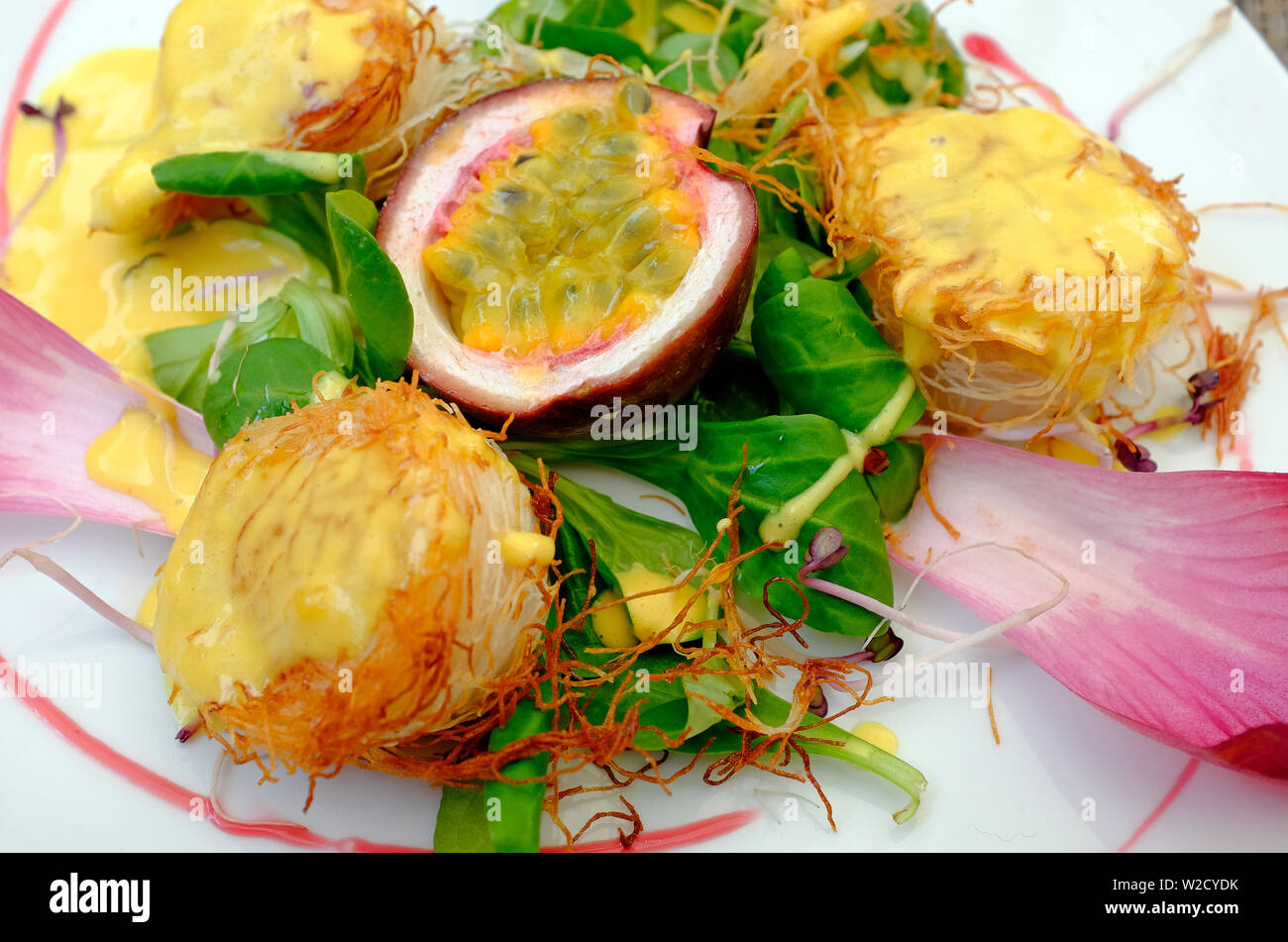 Capesante con il frutto della passione, radicchio lattuga e germogli di piselli Foto Stock
