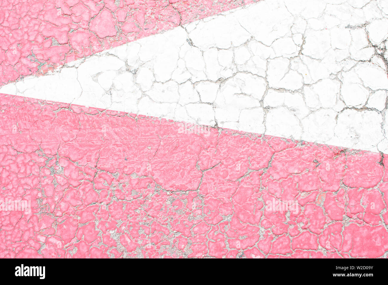 Rosa e Bianco vecchia vernice incrinata, incrinato dal calore del sole sulla superficie di calcestruzzo. Ottimo per la progettazione e la consistenza dello sfondo. Foto Stock
