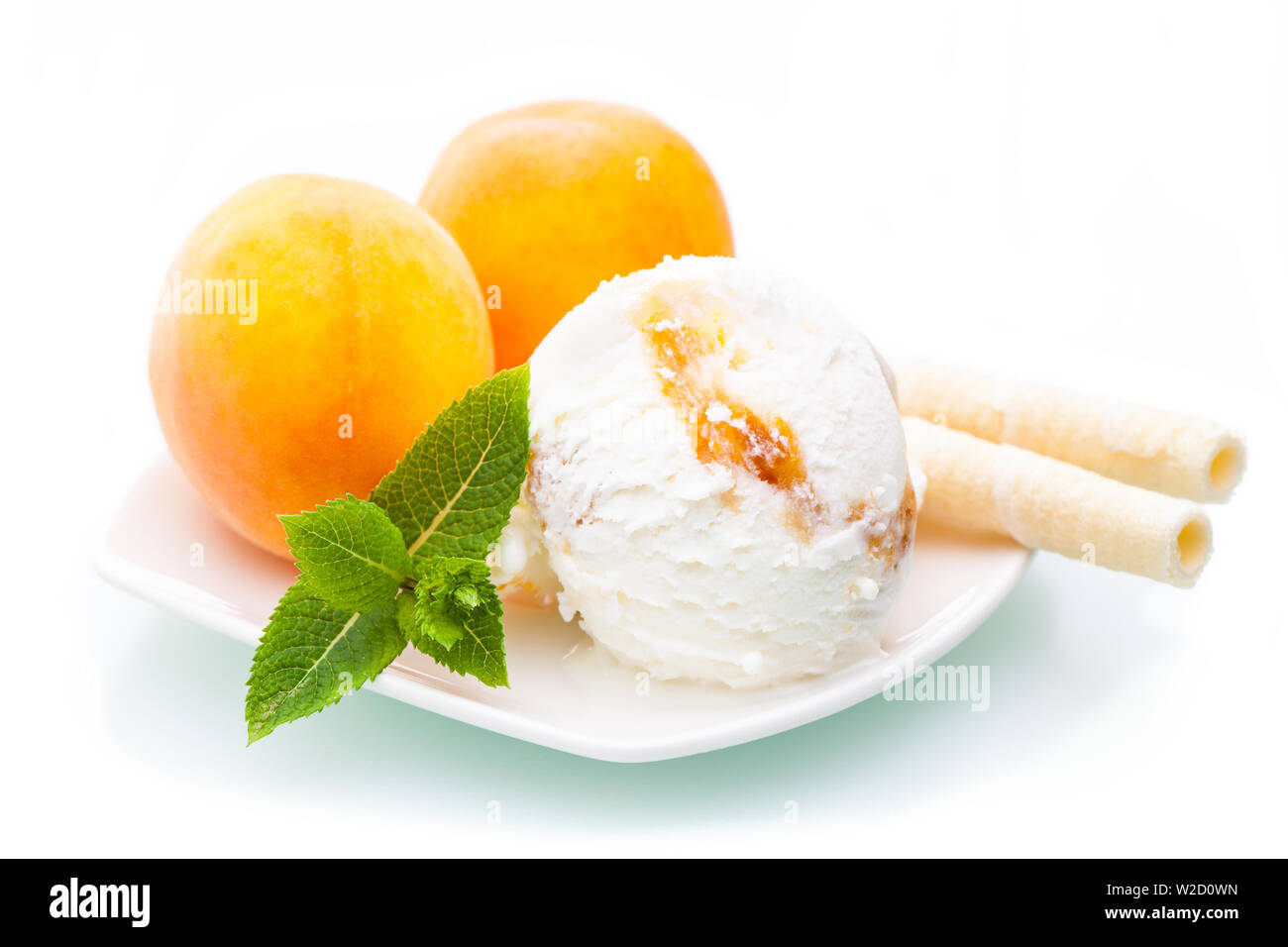 Gelato gelato: Albicocca gelato con frutti di un waffle su una piastra su sfondo bianco Foto Stock