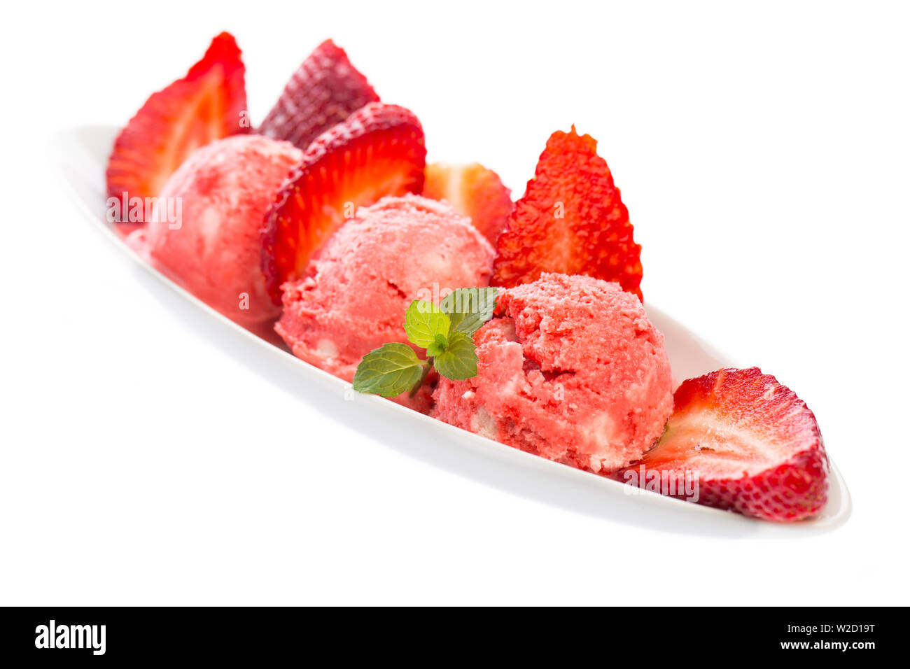 Gelato gelato: gelato: Gelato alla fragola in una ciotola con le fragole su un tavolo bianco Foto Stock