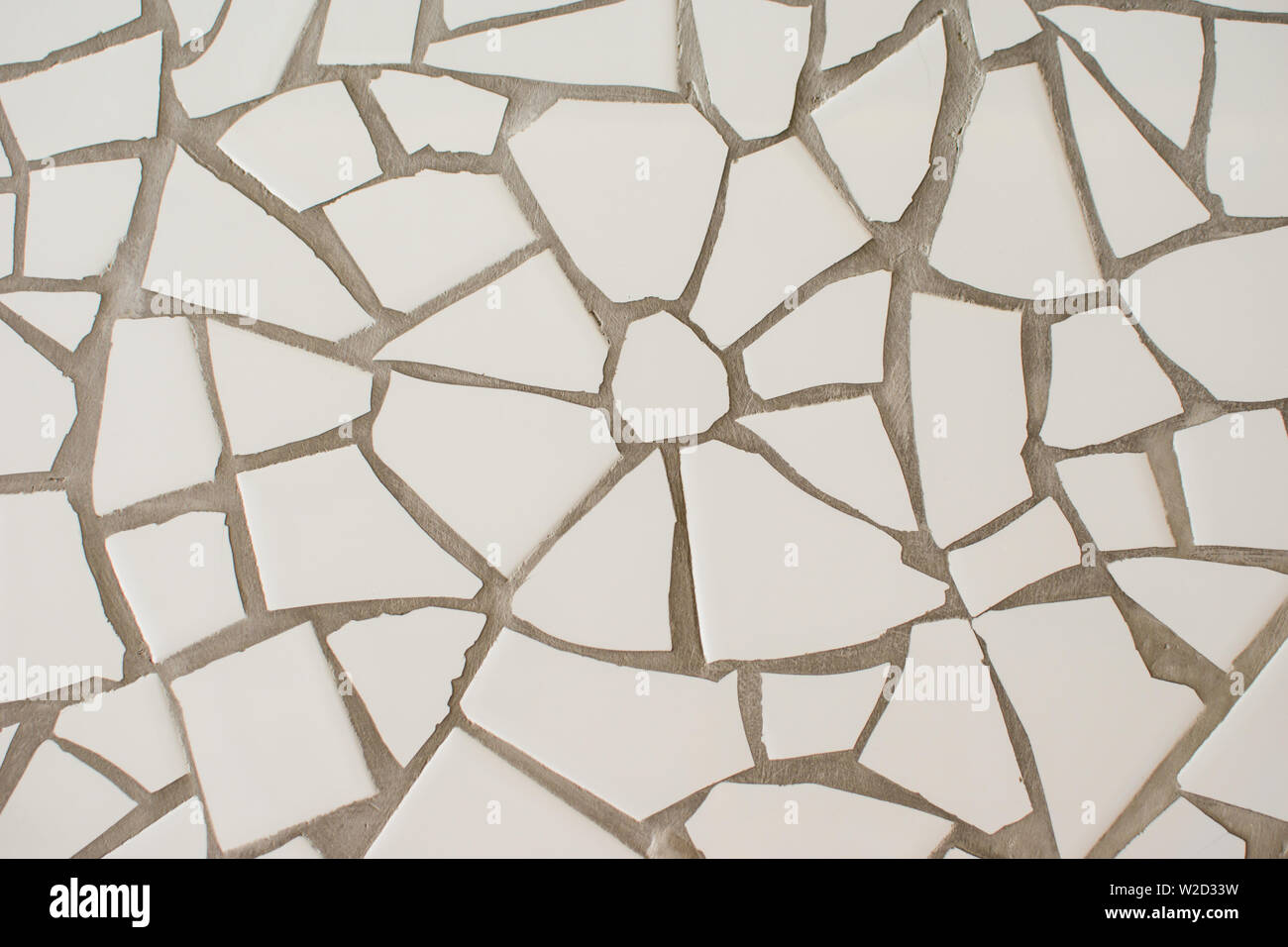 La superficie di molte piccole piastrelle bianche di diverse forme. Abstract mosaico di piastrelle in ceramica modellato sullo sfondo. Ottimo per la progettazione e lo sfondo di texture Foto Stock