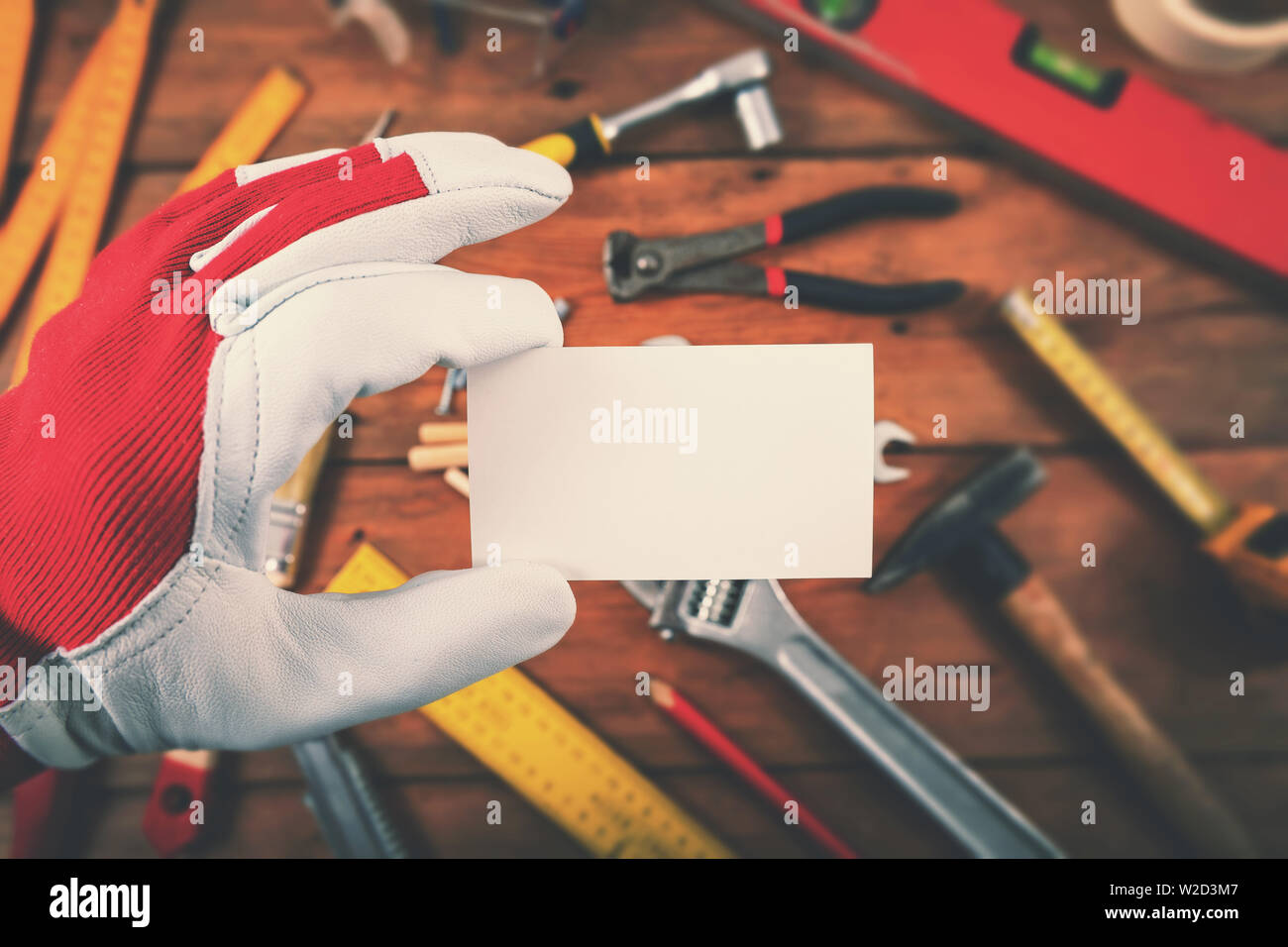 Addetto alla manutenzione e riparazione della casa servizi - mano azienda blank business card oltre gli strumenti di lavoro Foto Stock